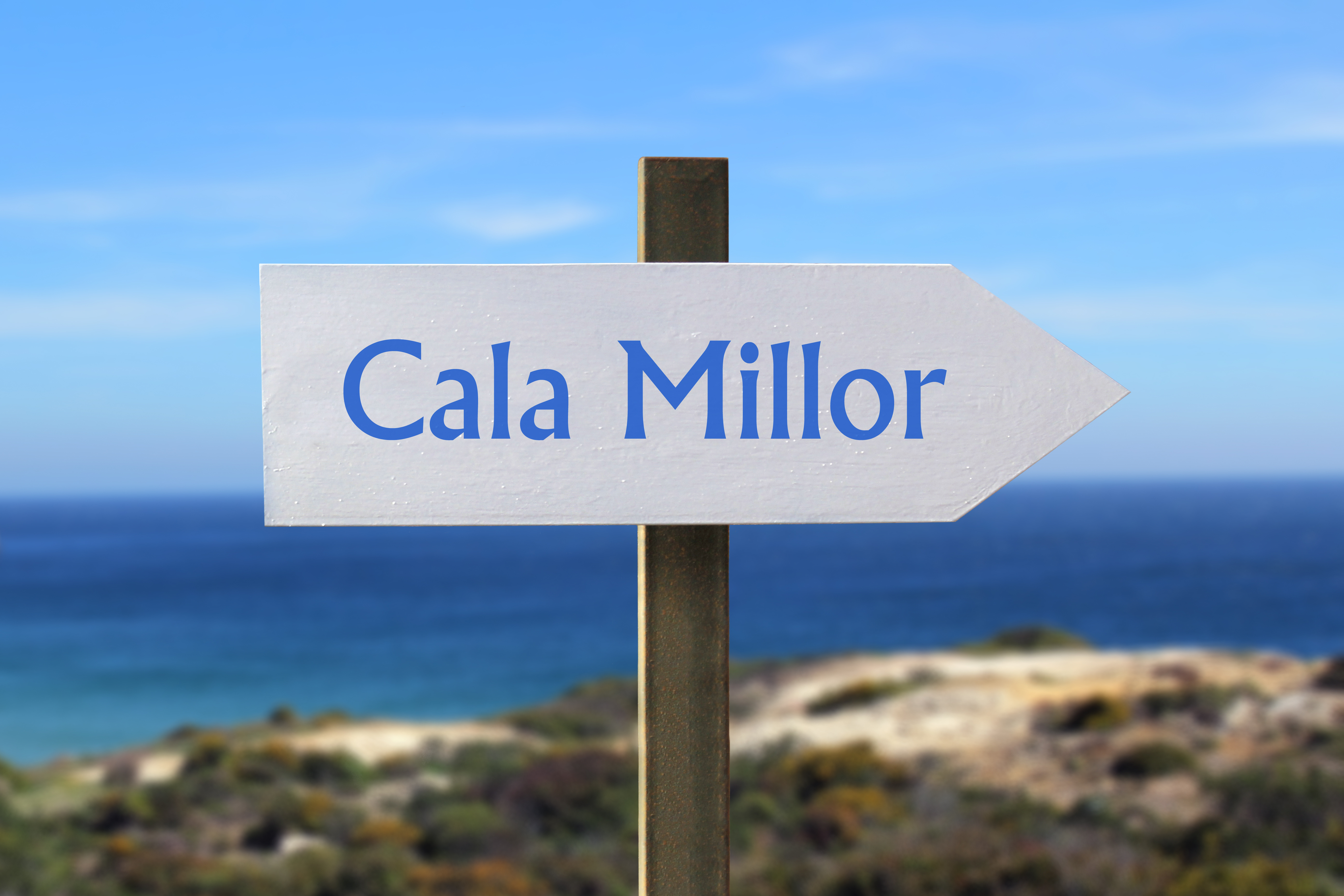 Cala Millor Ortsname in blauer Schrift auf Pfeil der nach rechts zeigt