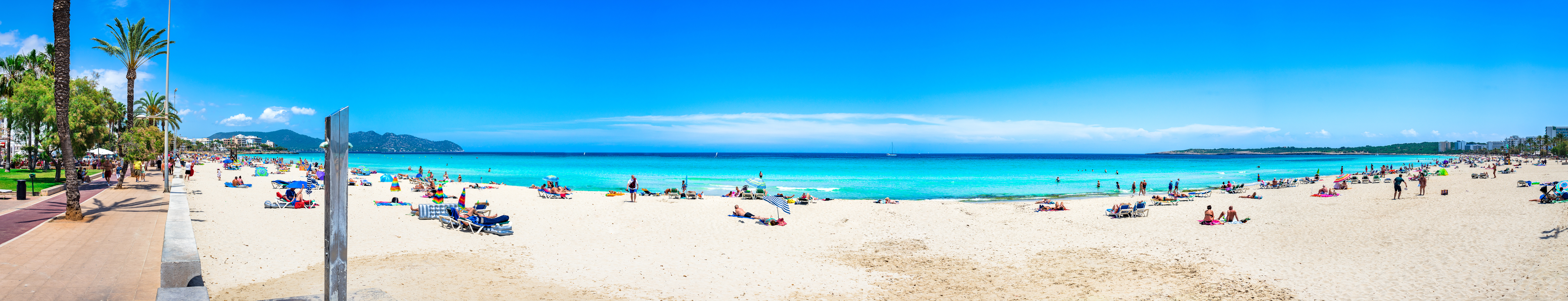 Panorama plaży Cala Millor przy jasnym niebieskim niebie