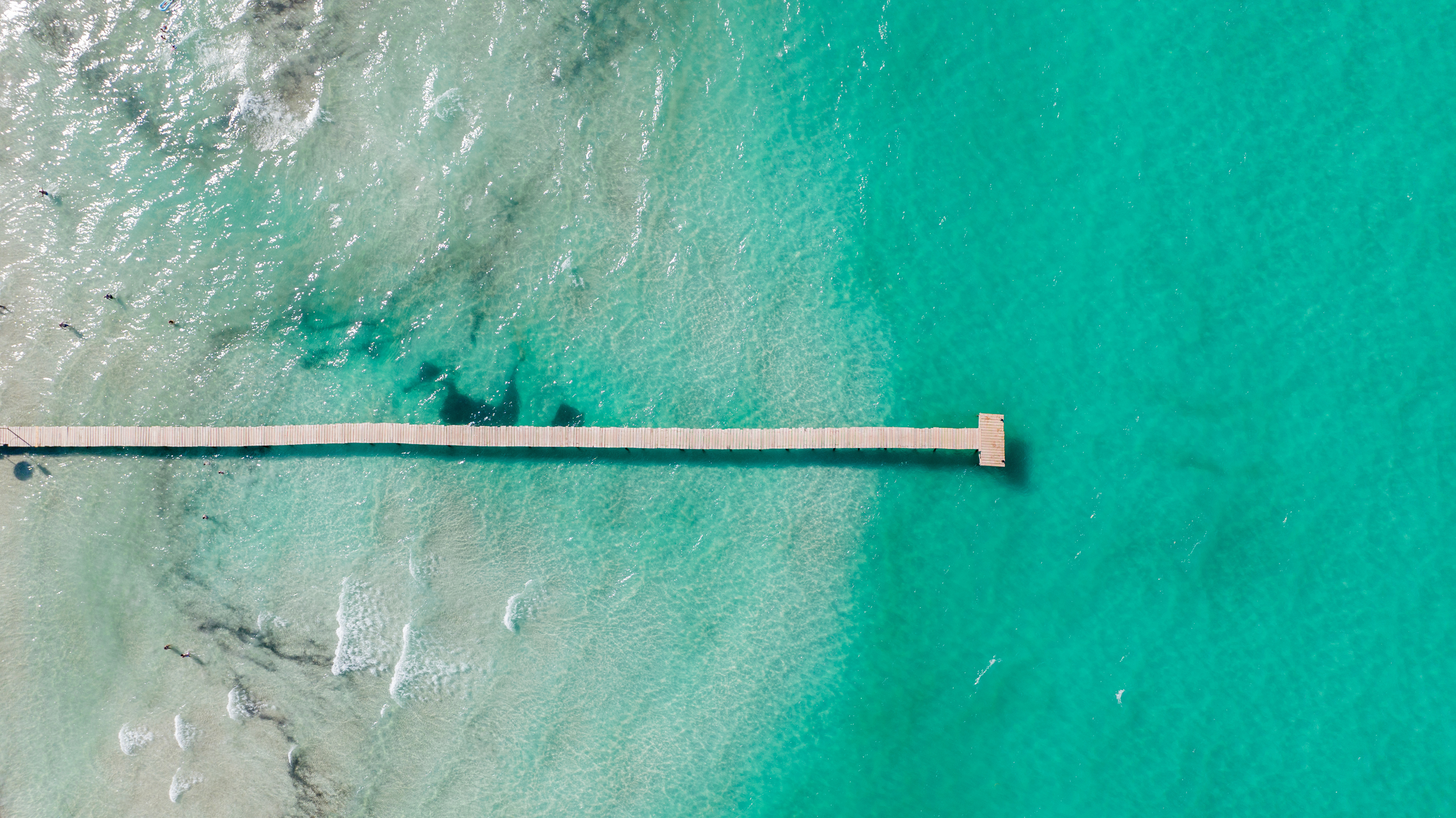 Luchtfoto van een pier die zich uitstrekt in de turkooizen zee in Alcúdia