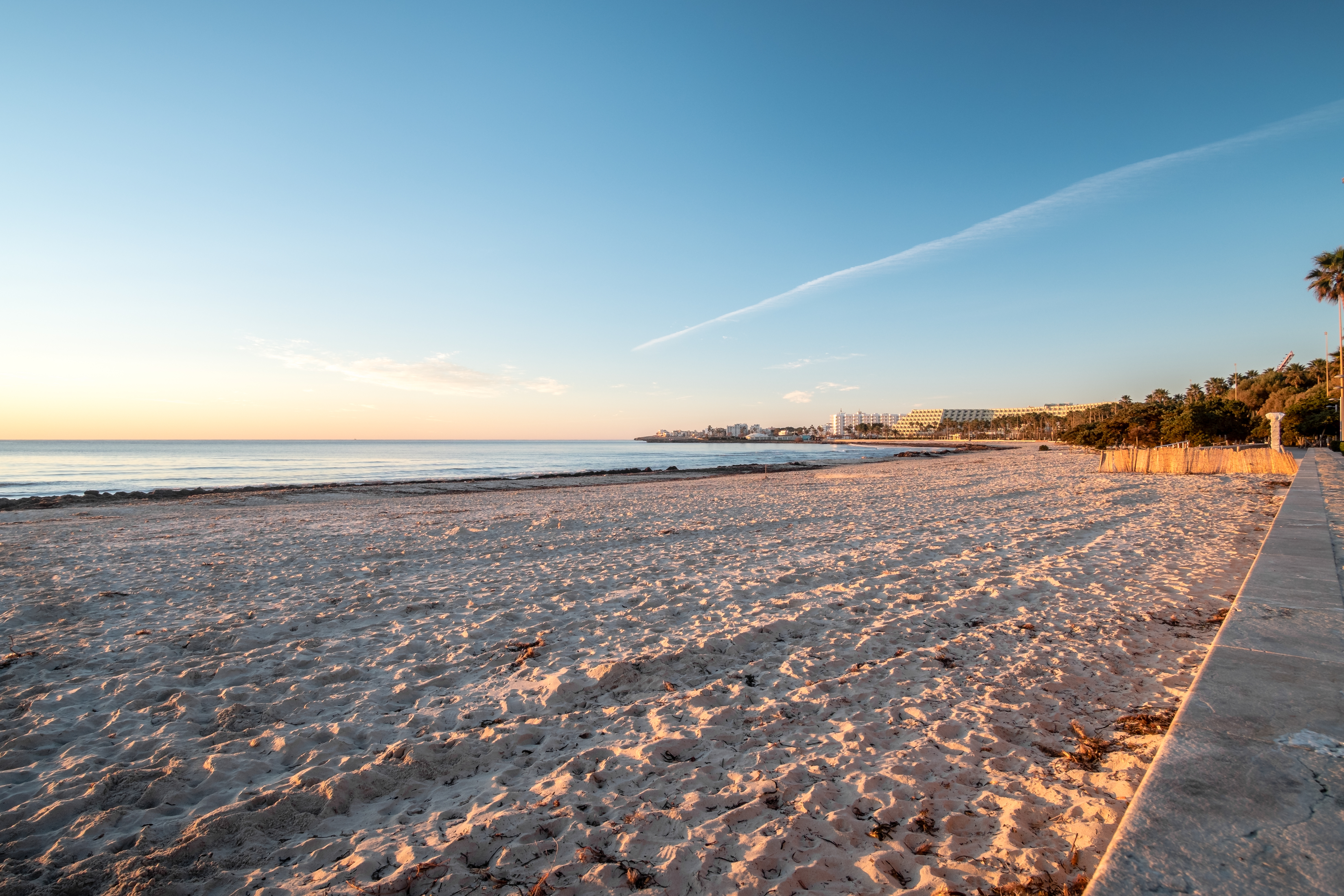 Het lichte, fijne zand van het strand van Sa Coma bij zonsondergang