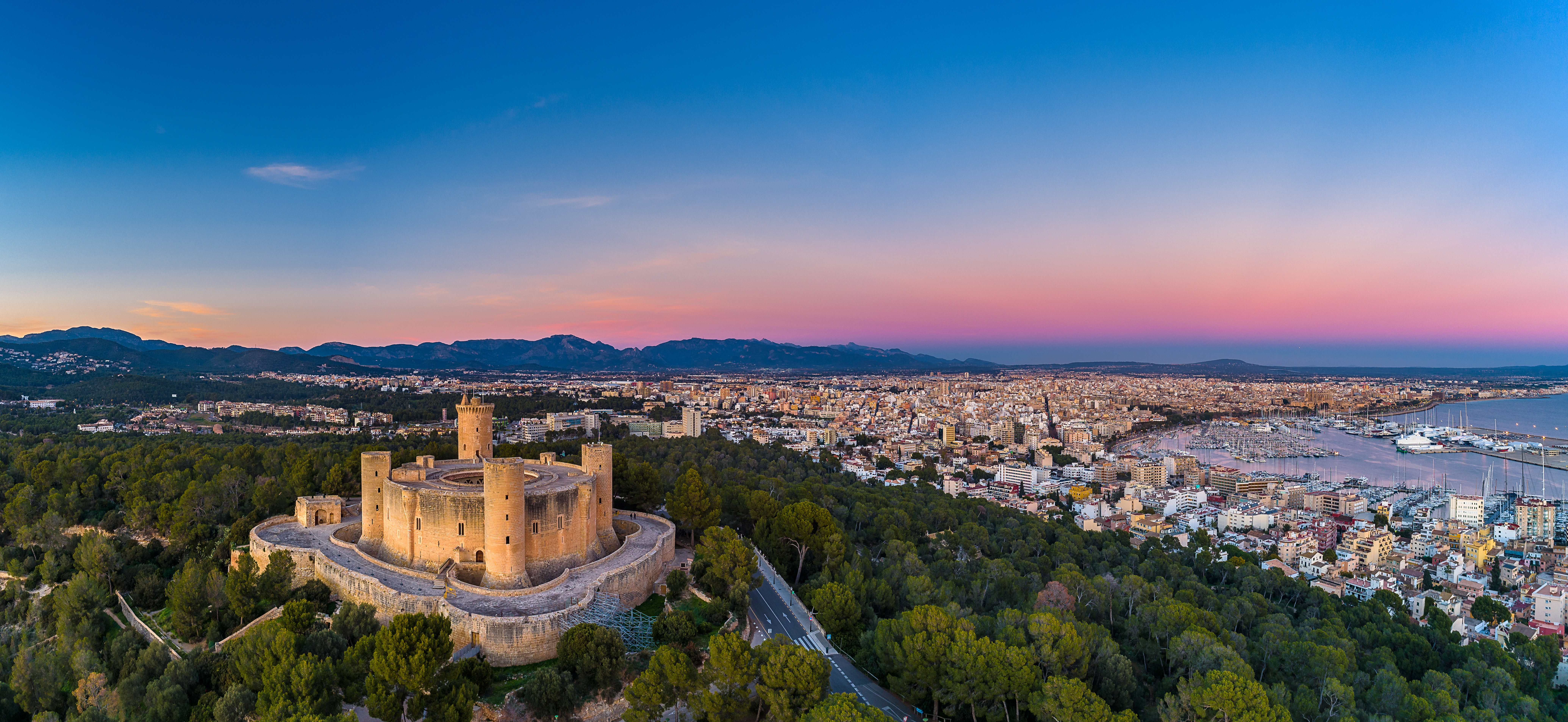 Kasteel, stad en haven op Mallorca bij zonsondergang