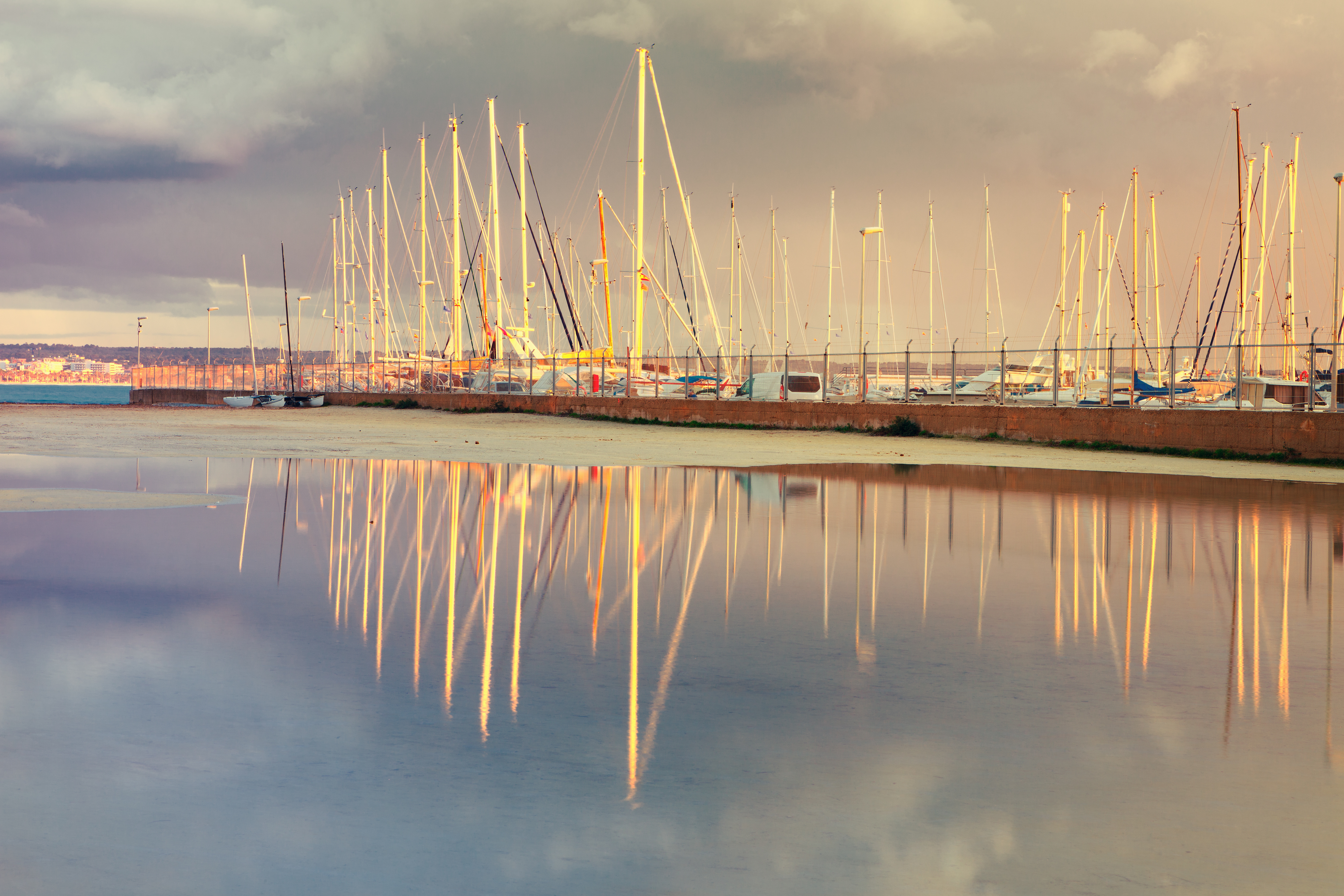 Fantastic sunset at the Can Pastilla marina. Small white sailboats lie at anchor