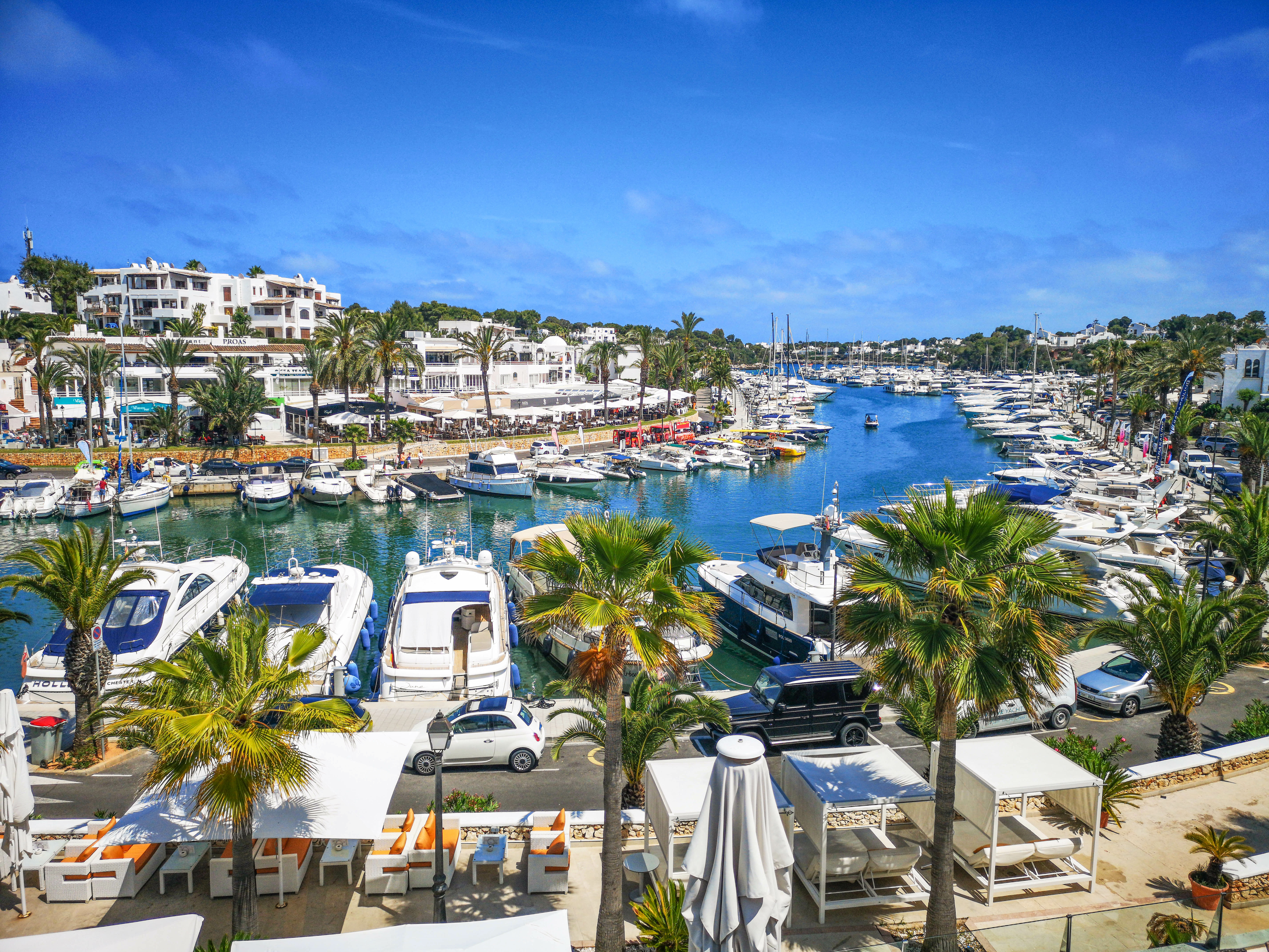 The small boats are moored close together in the port of Cala d'Or