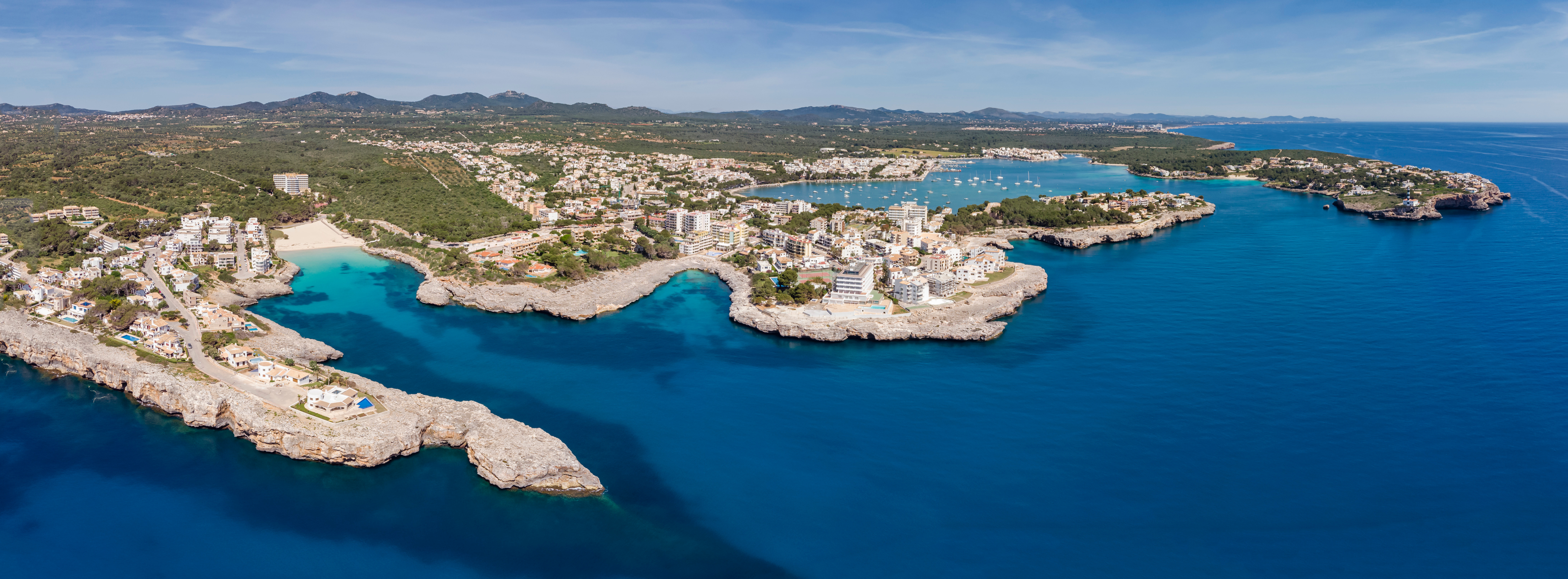 Luchtfoto van Porto Colom met schaarse rotsen en kleine prachtige zwembaaien