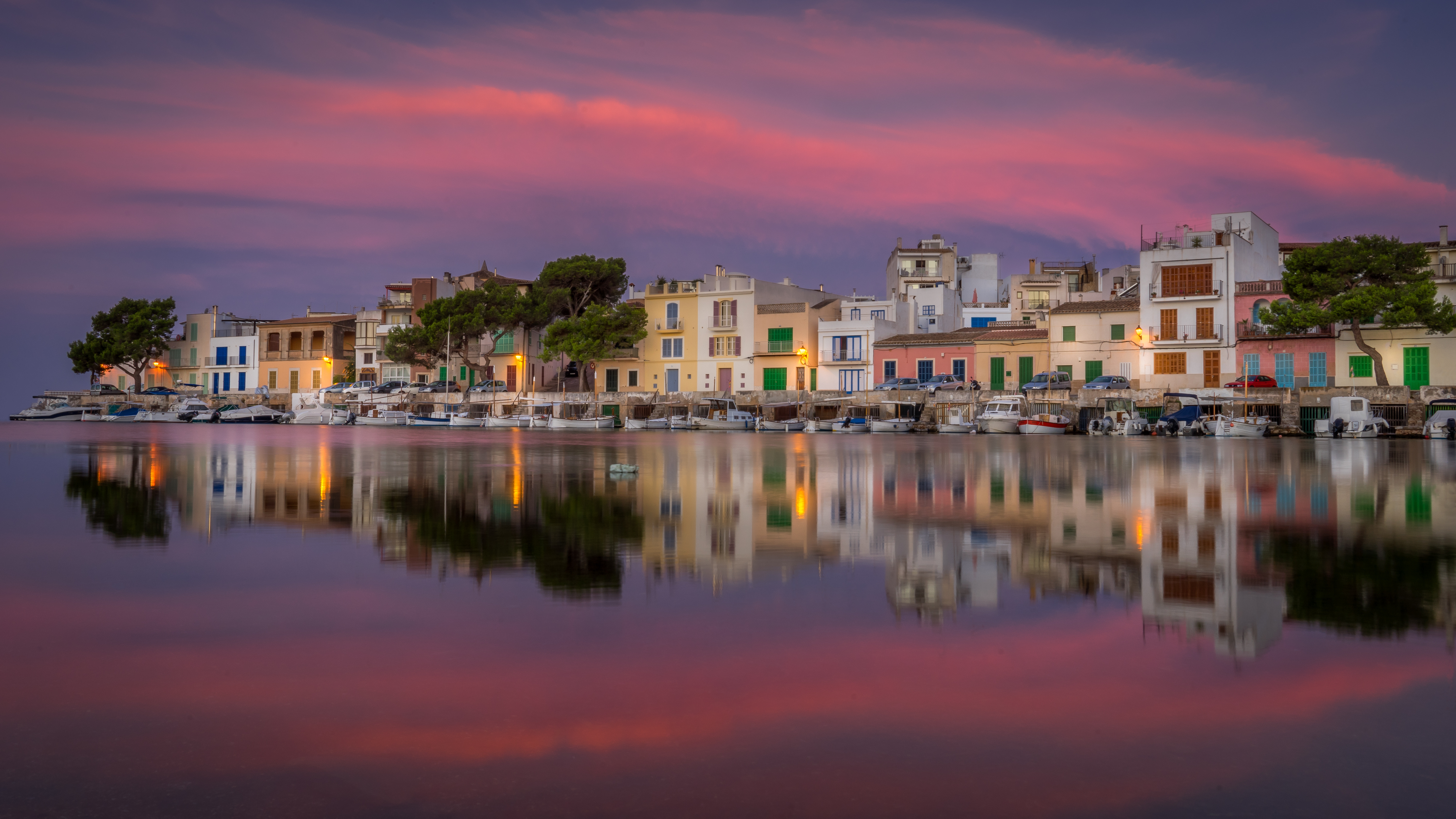 Tramonto mozzafiato tinge la baia di Porto Colom in un fantastico gioco di colori