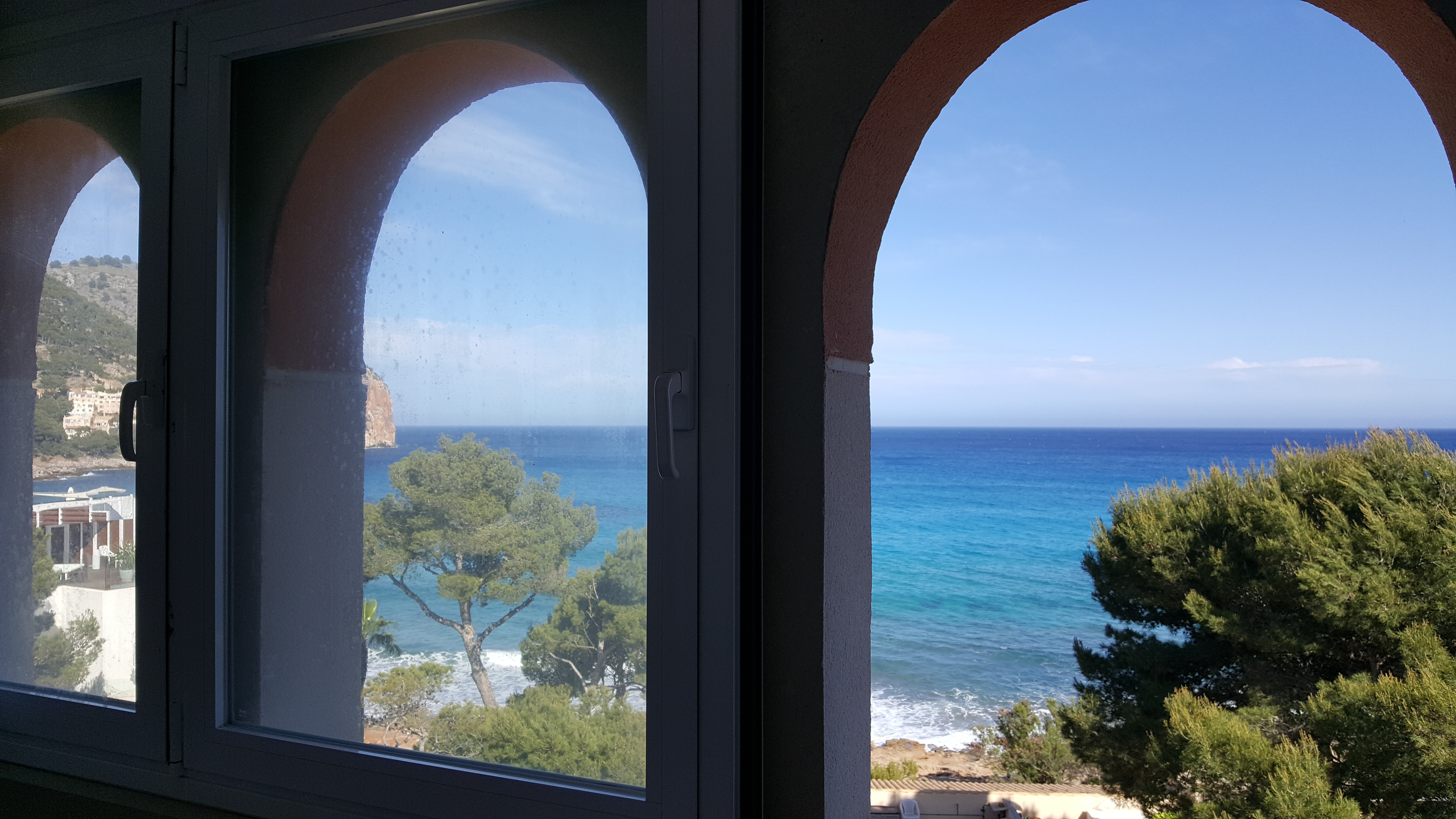 Ausblick auf die Bucht von Canyamel mit tiefblauem Wasser und alten Pinien