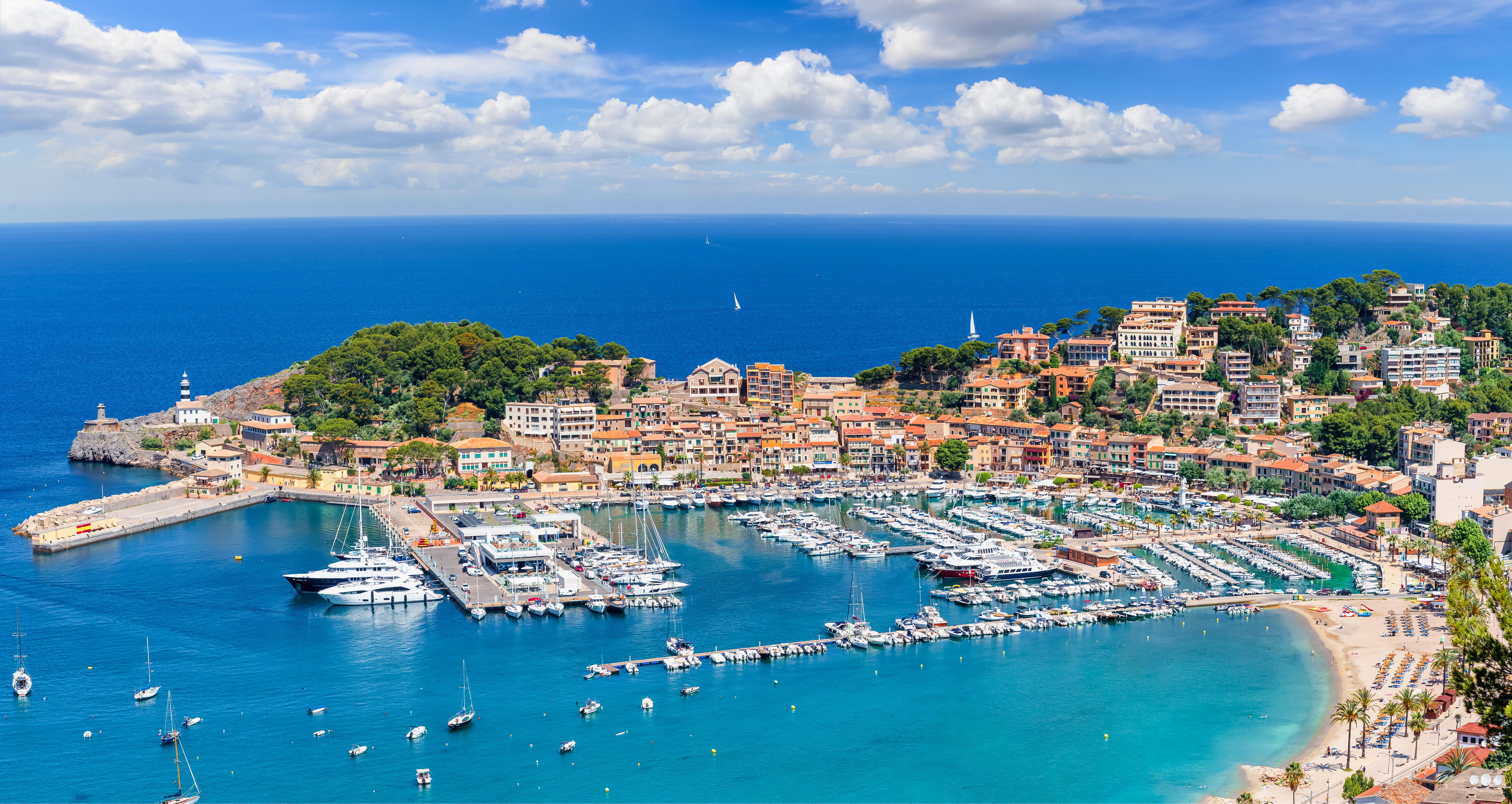 Płaska piaszczysta plaża Port de Soller płynnie przechodzi w mały port