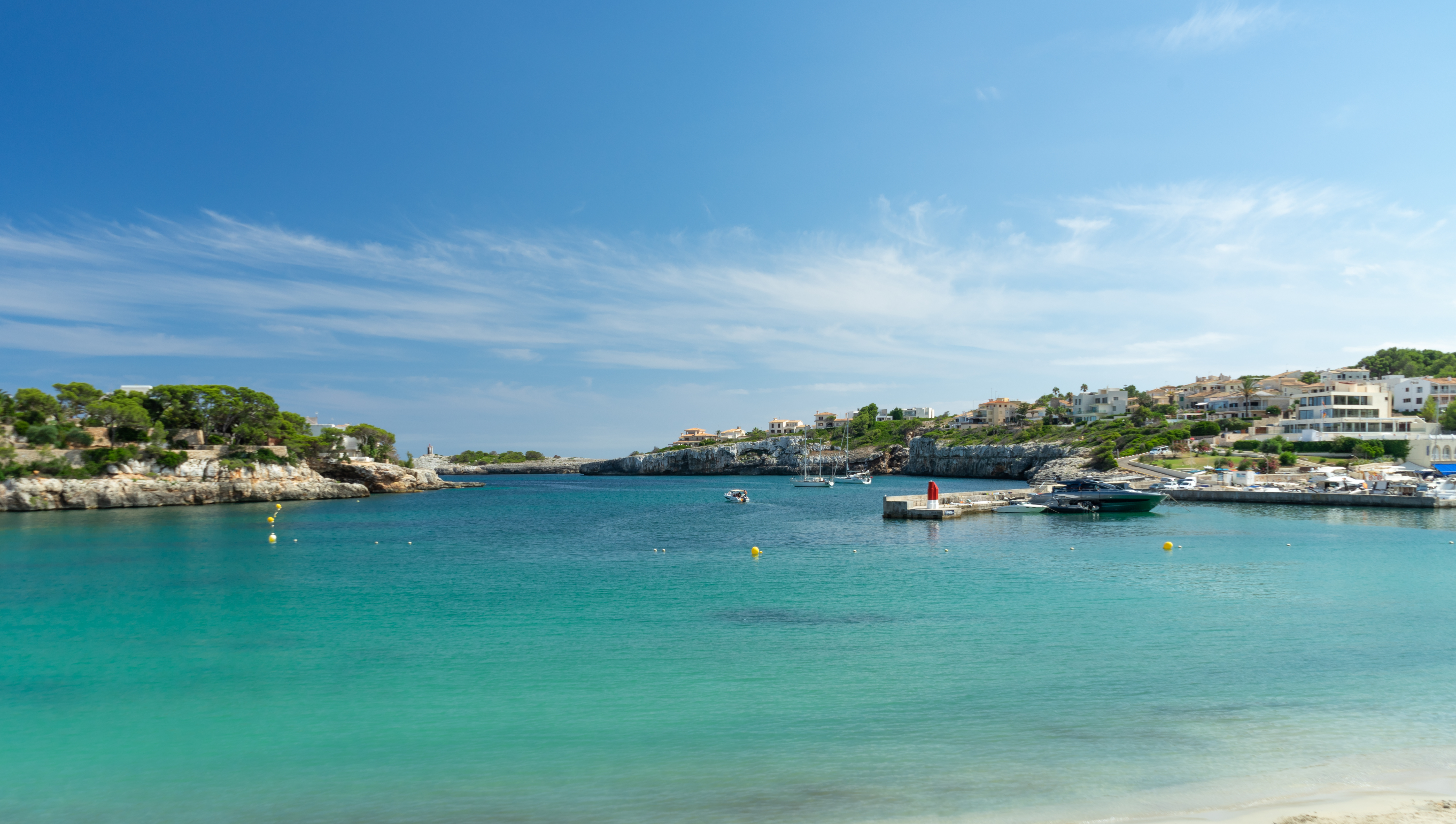 The small bay of Porto Cristo with a bathing beach and turquoise blue water