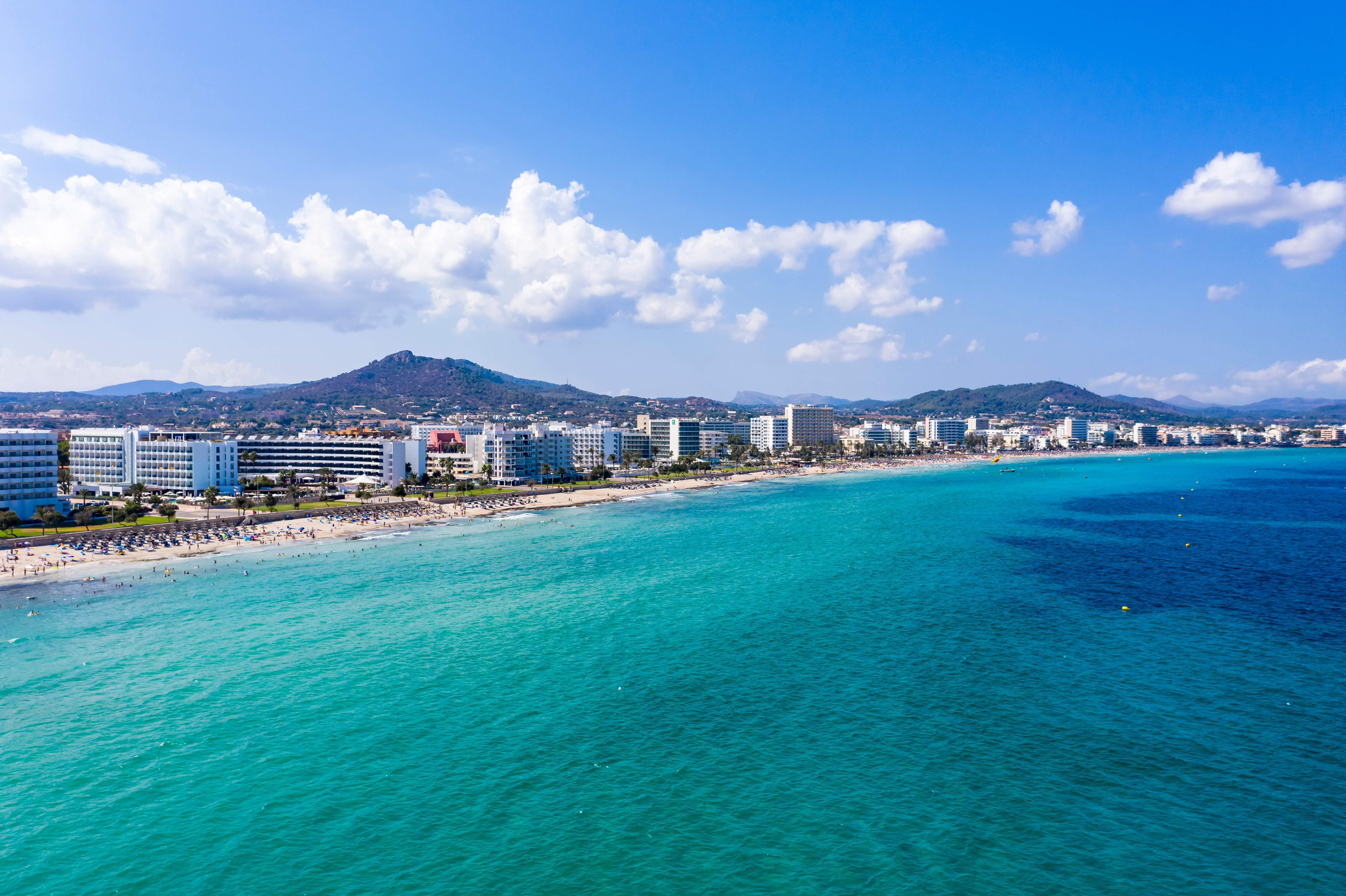 Vista aérea de la bahía de Cala Bona con el horizonte del hotel al fondo