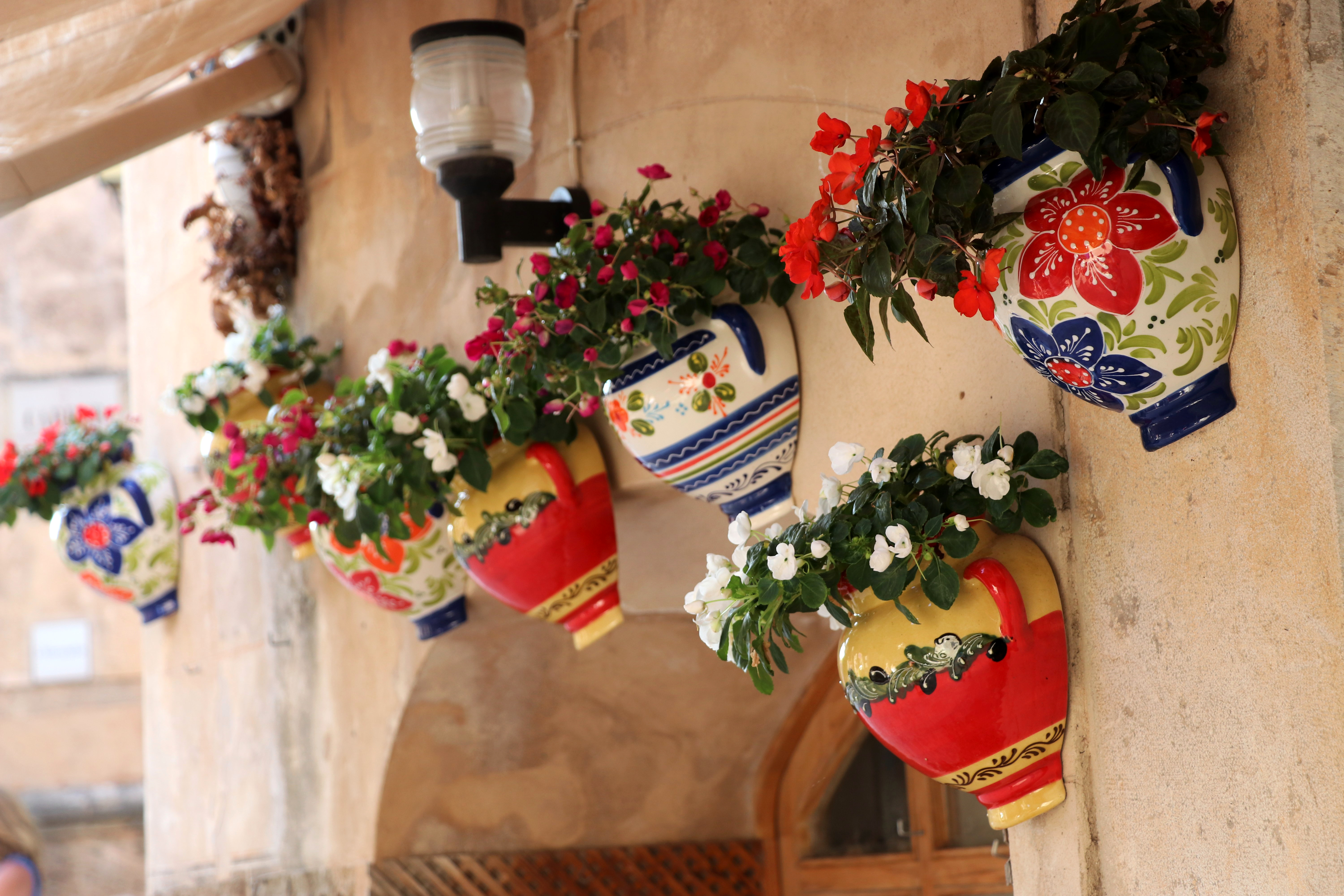 Kleurrijke, mooi beplante bloempotten versieren de ingang van een huis