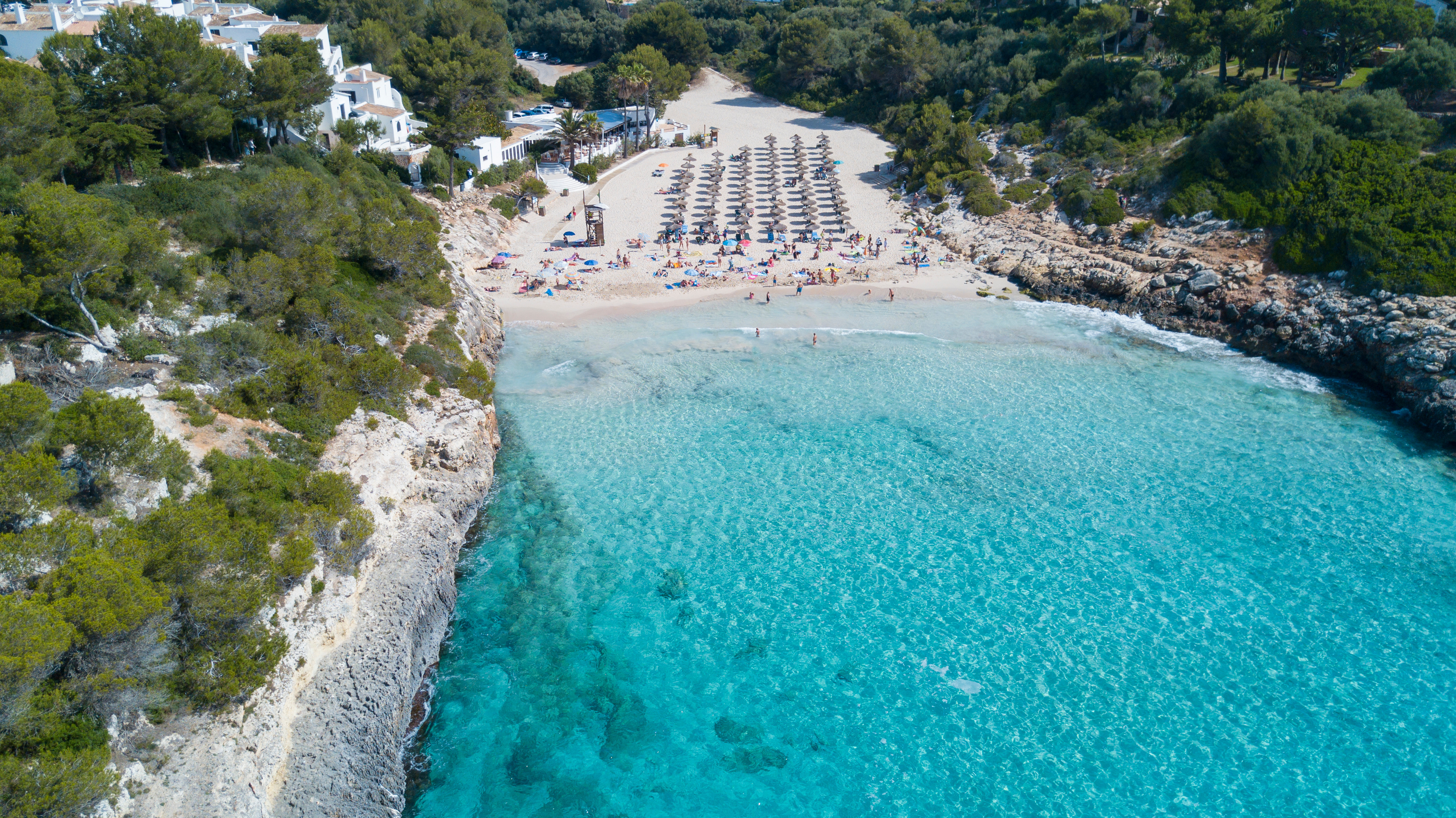 Pittoreske baai met wit zand en turquoise water in Cala Mandia