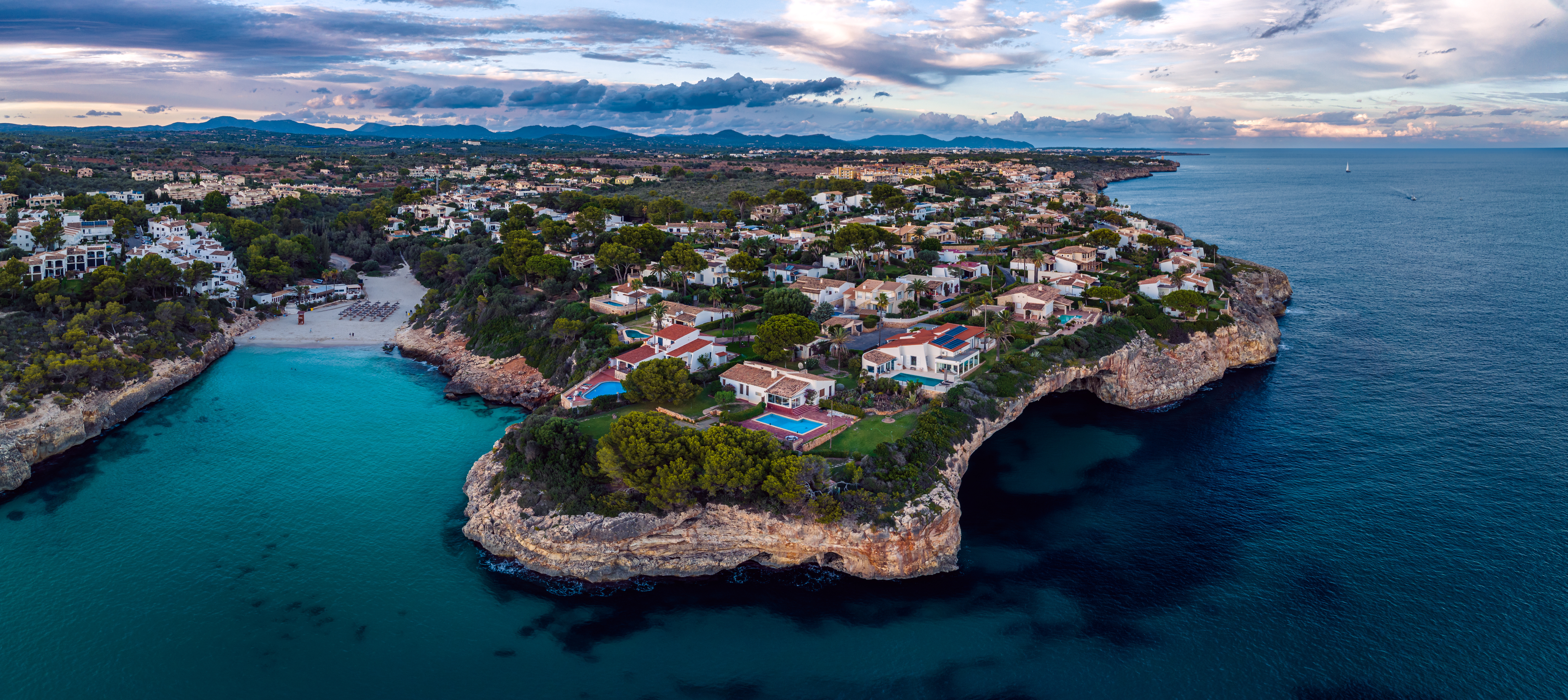 Cala Mandia'nın derin mavi sularıyla kayalık kıyısı