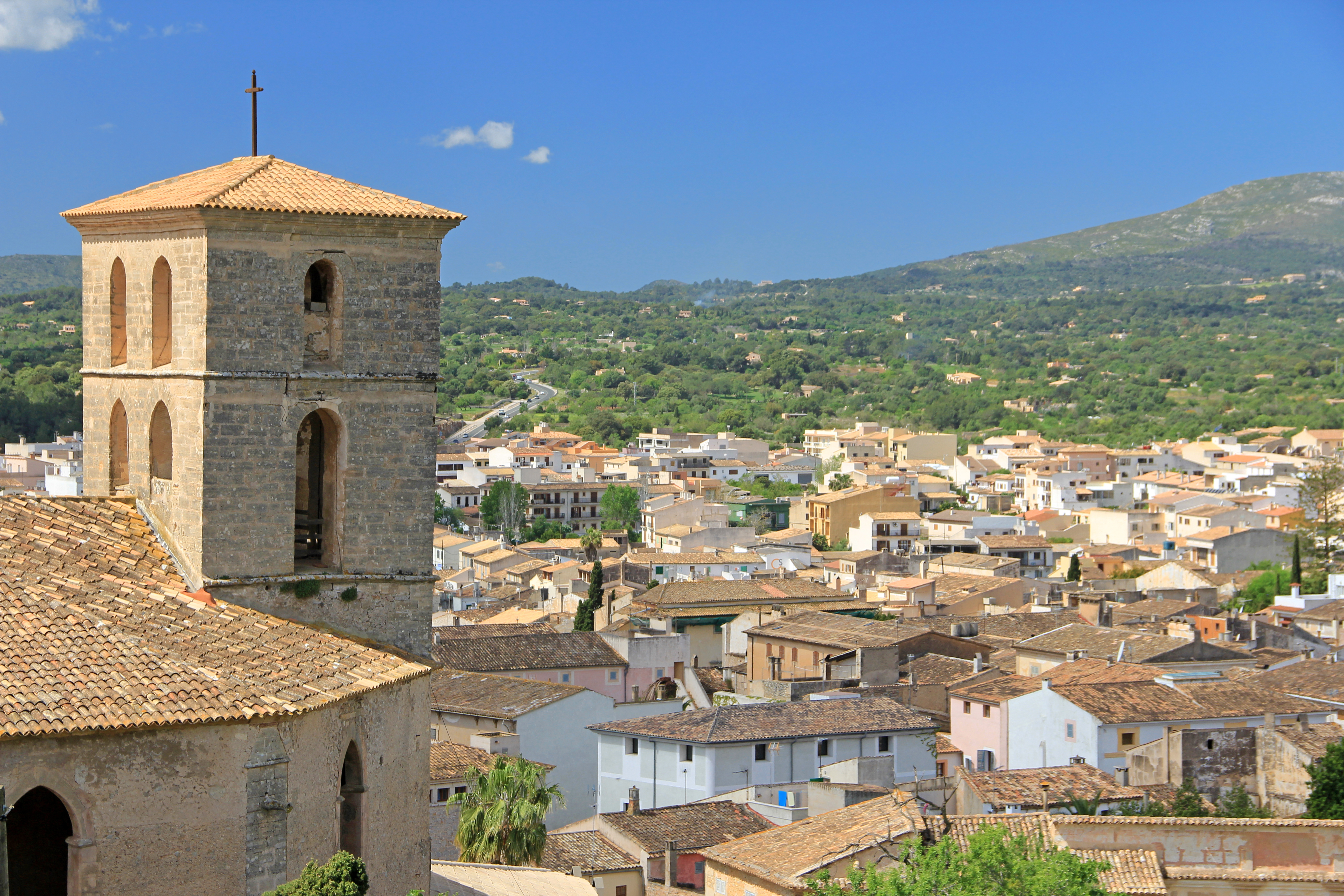 Over the rooftops of Artà with forest and mountain in the background