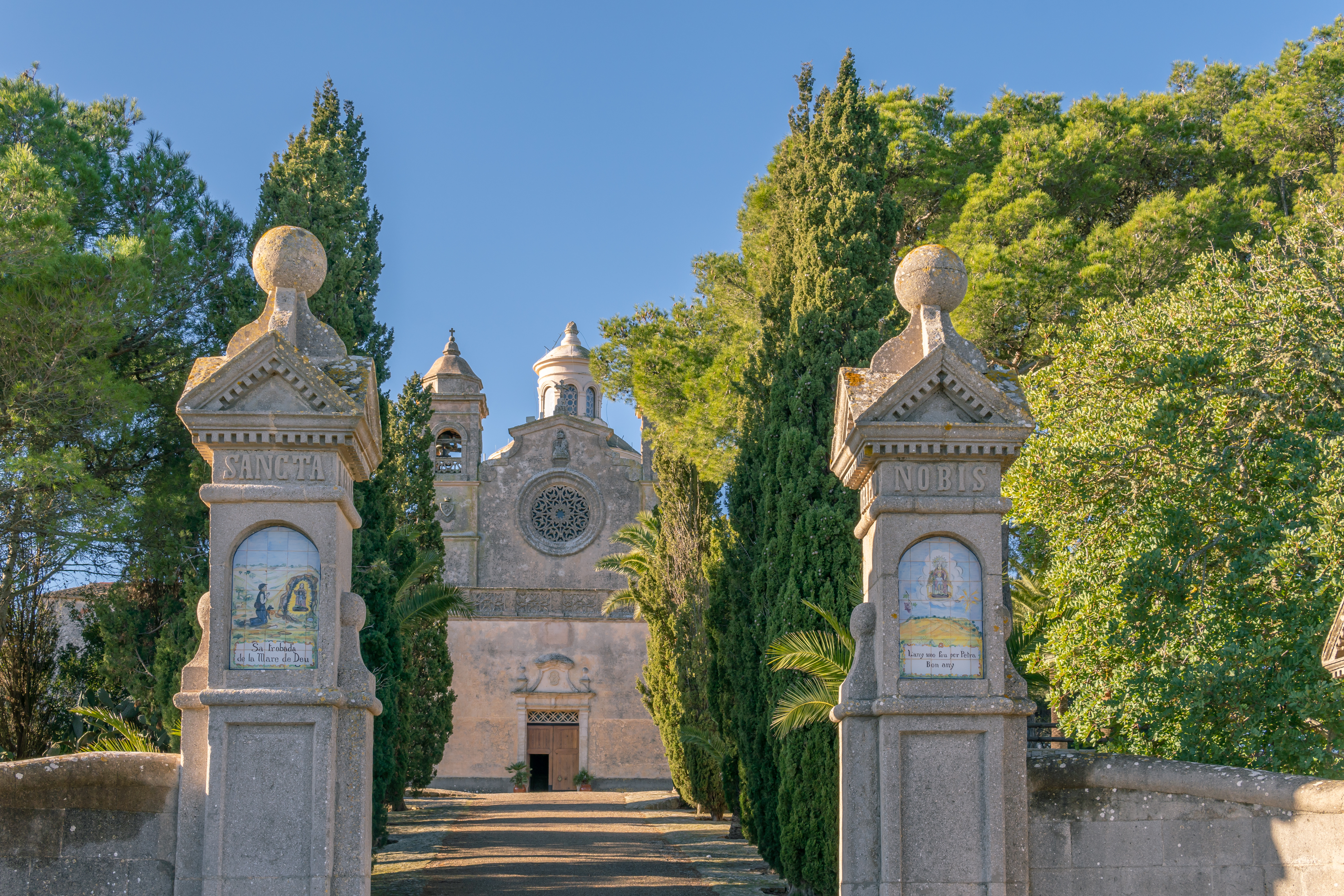 Imponente ingresso alla cappella di Bonany in mezzo a un bosco di pini