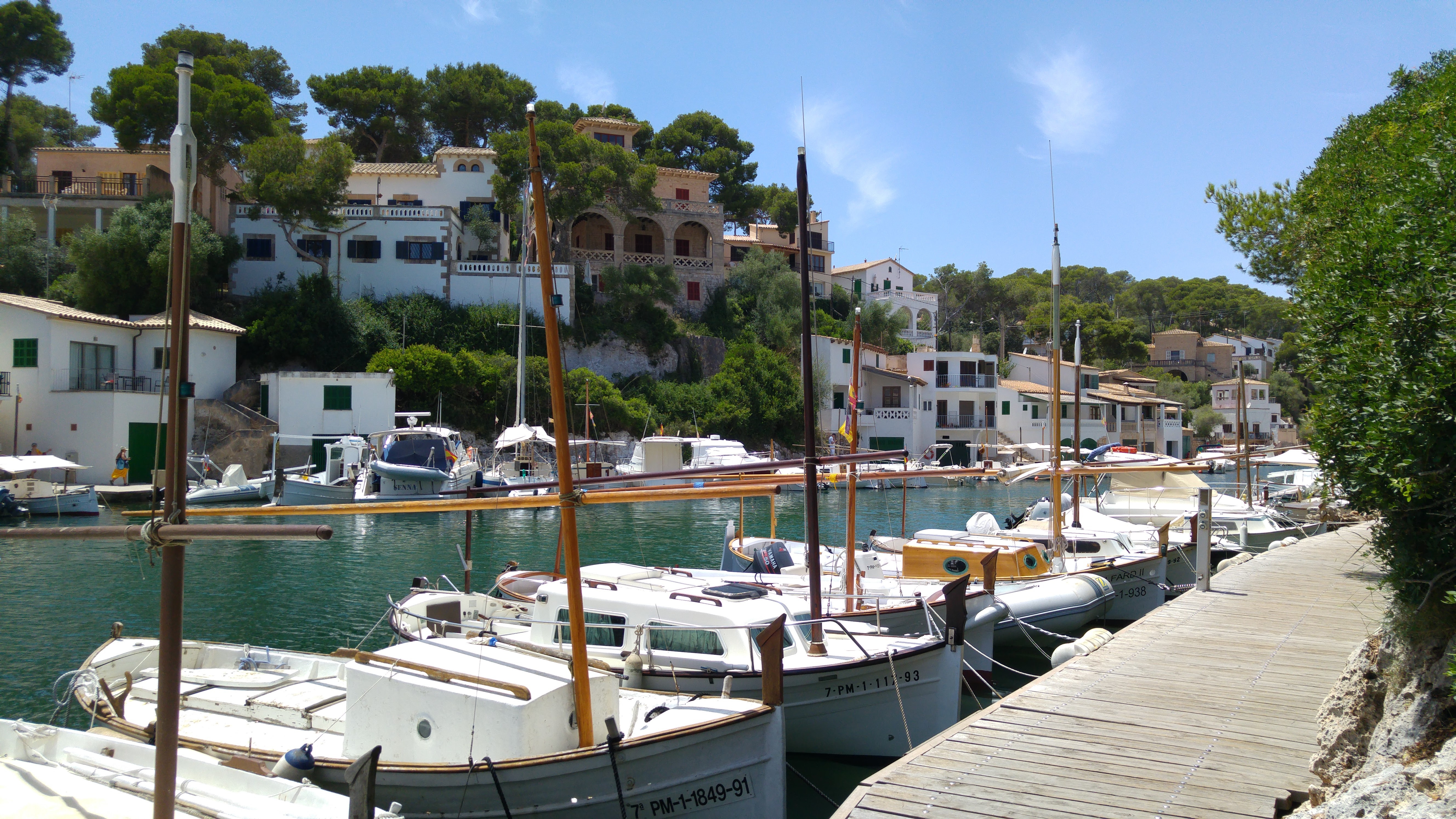 Incantevole piccolo porto di Cala Llombards con vecchie case e piccole barche da pesca