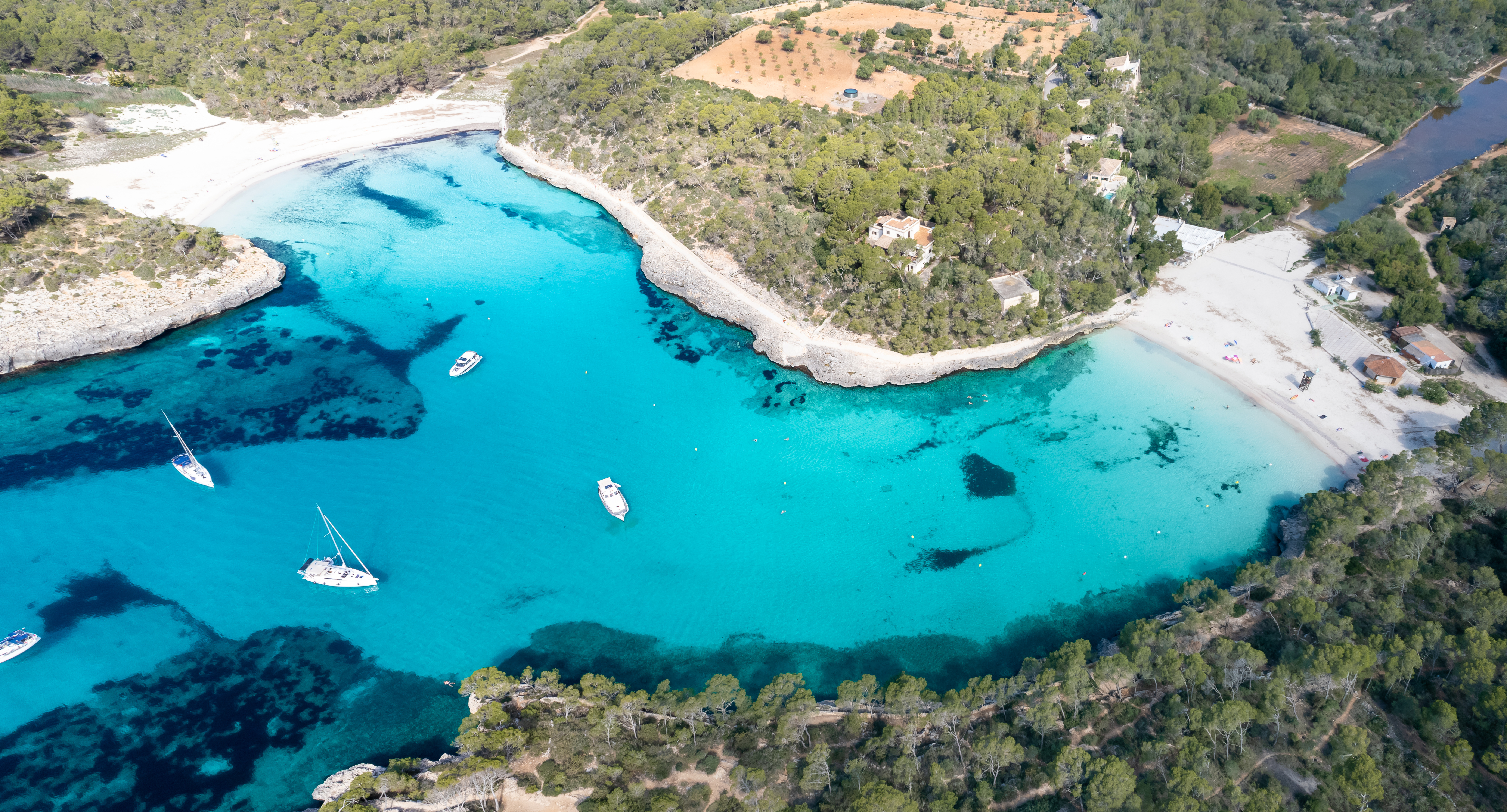 Luftaufnahme der wunderschönen Badebuchten von Cala Mondrago mit schneeweißen Stränden