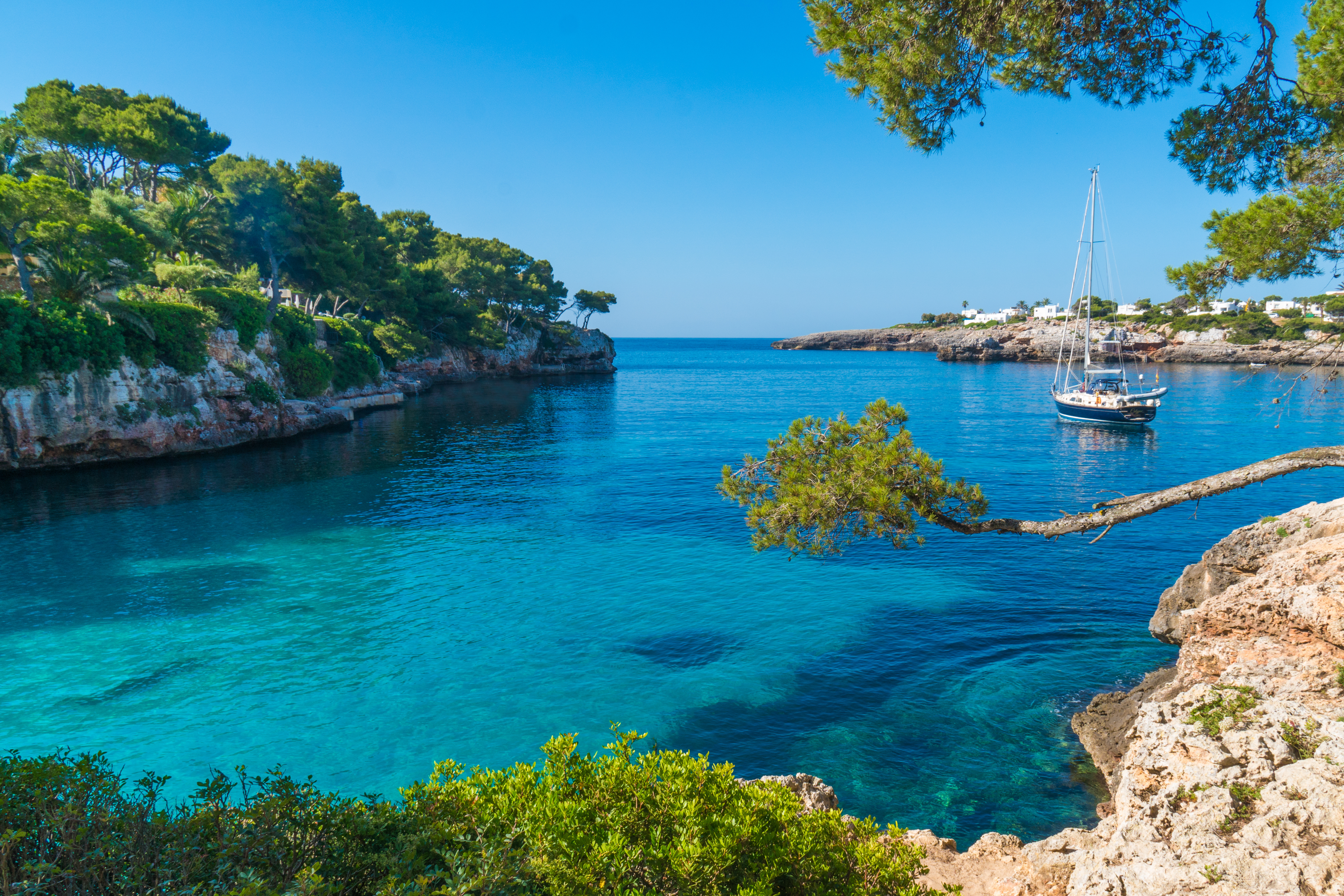 A small fishing boat floats in the beautiful bay of Cala Serena