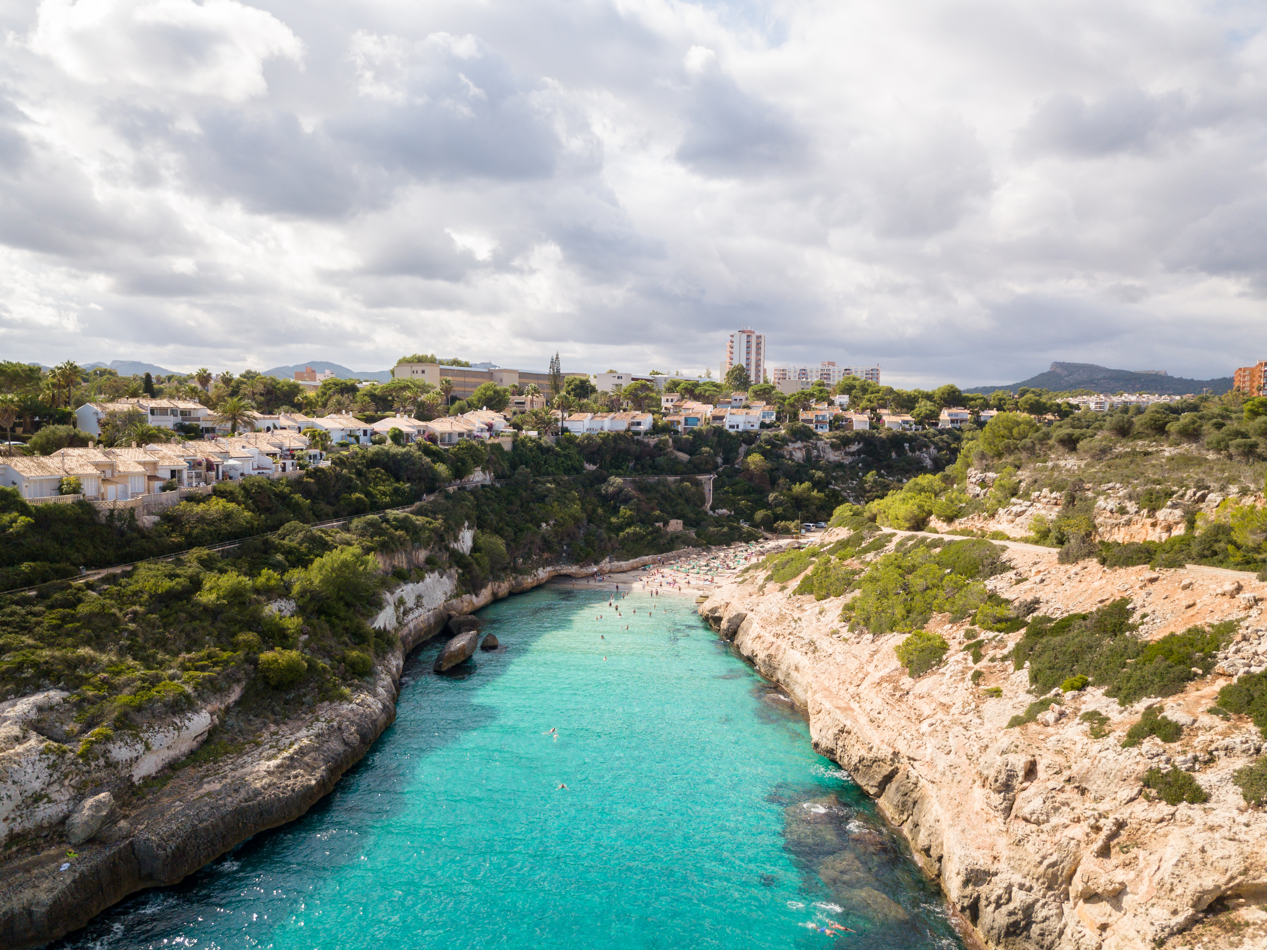 Aerial view of the bathing cove with cloudy sky over Cales de Mallorca