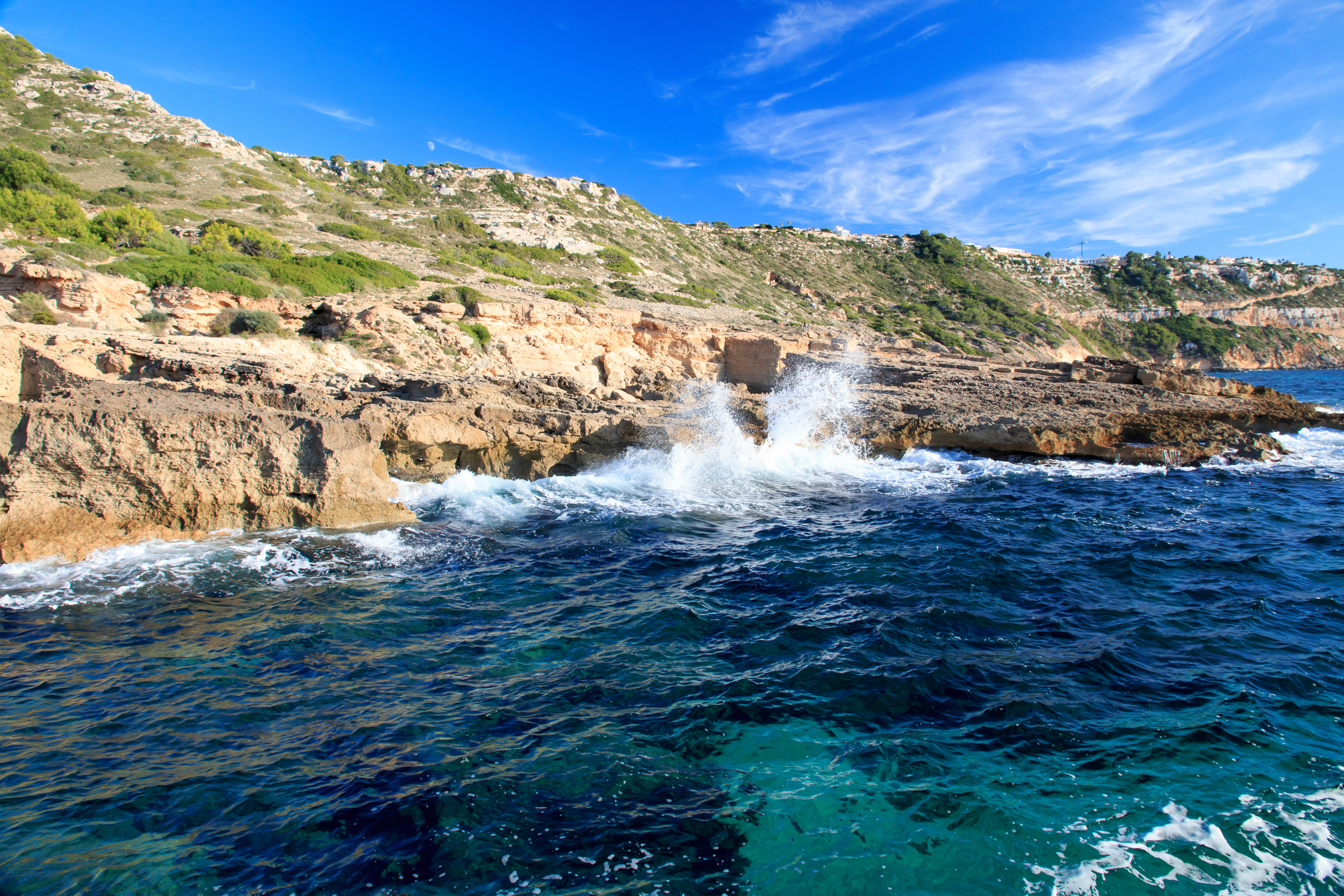 Uitzicht op de rotsachtige kust van Cala Blava met kristalhelder water