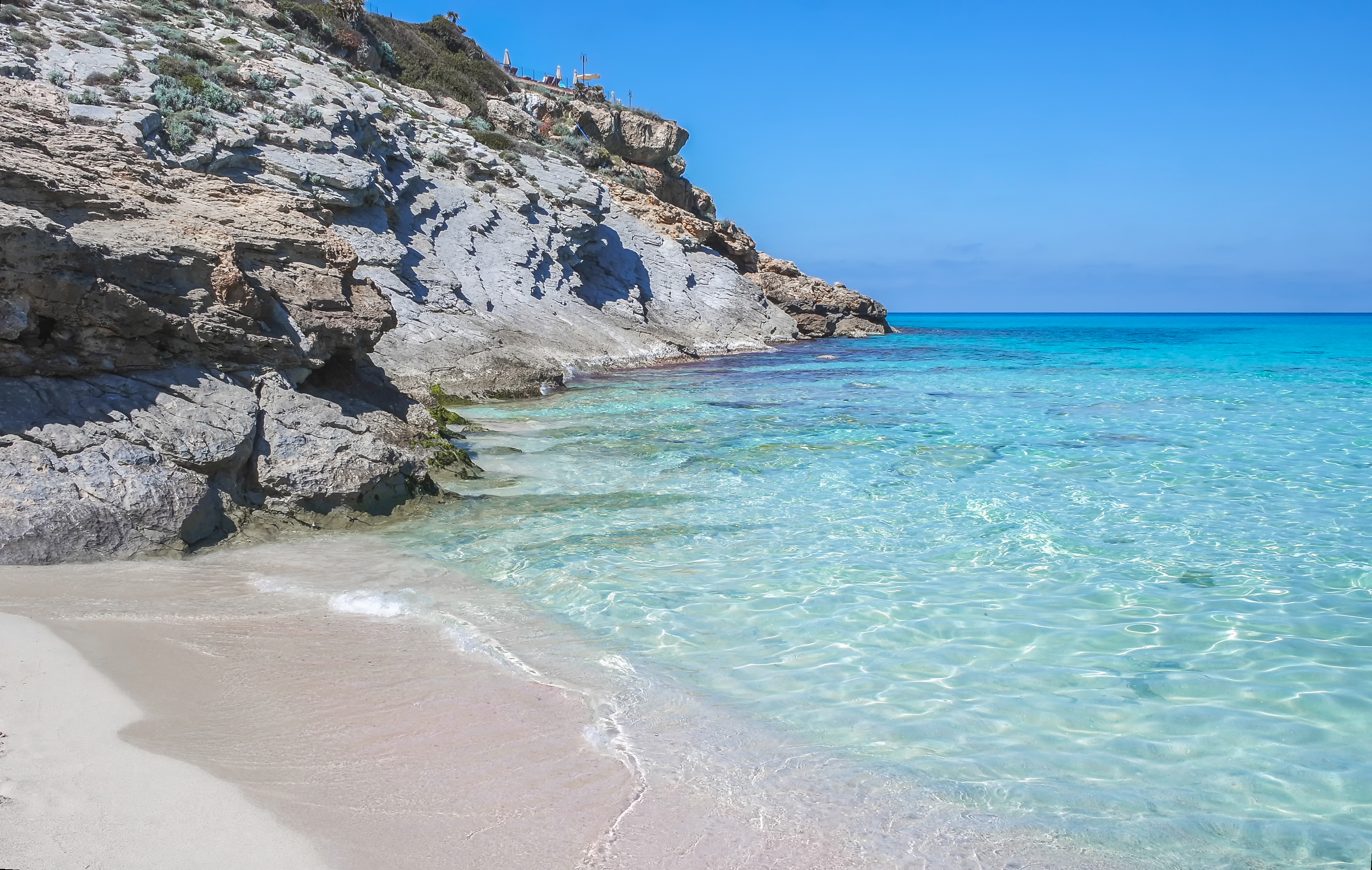 Cala Mesquida'nın yüzme koyunda kristal berraklığında su ve beyaz kum