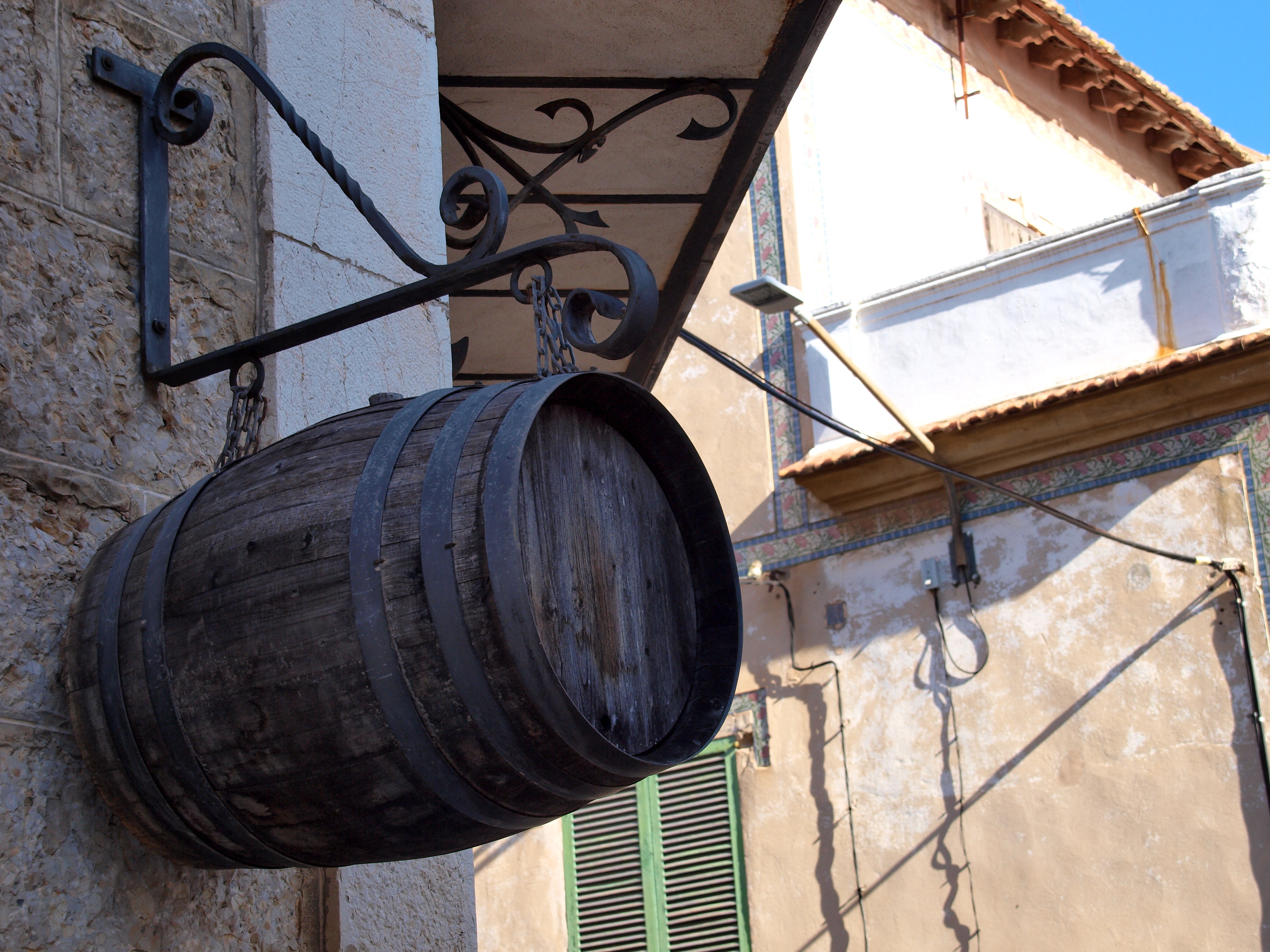 Botte di vino davanti a una vecchia facciata a Inca