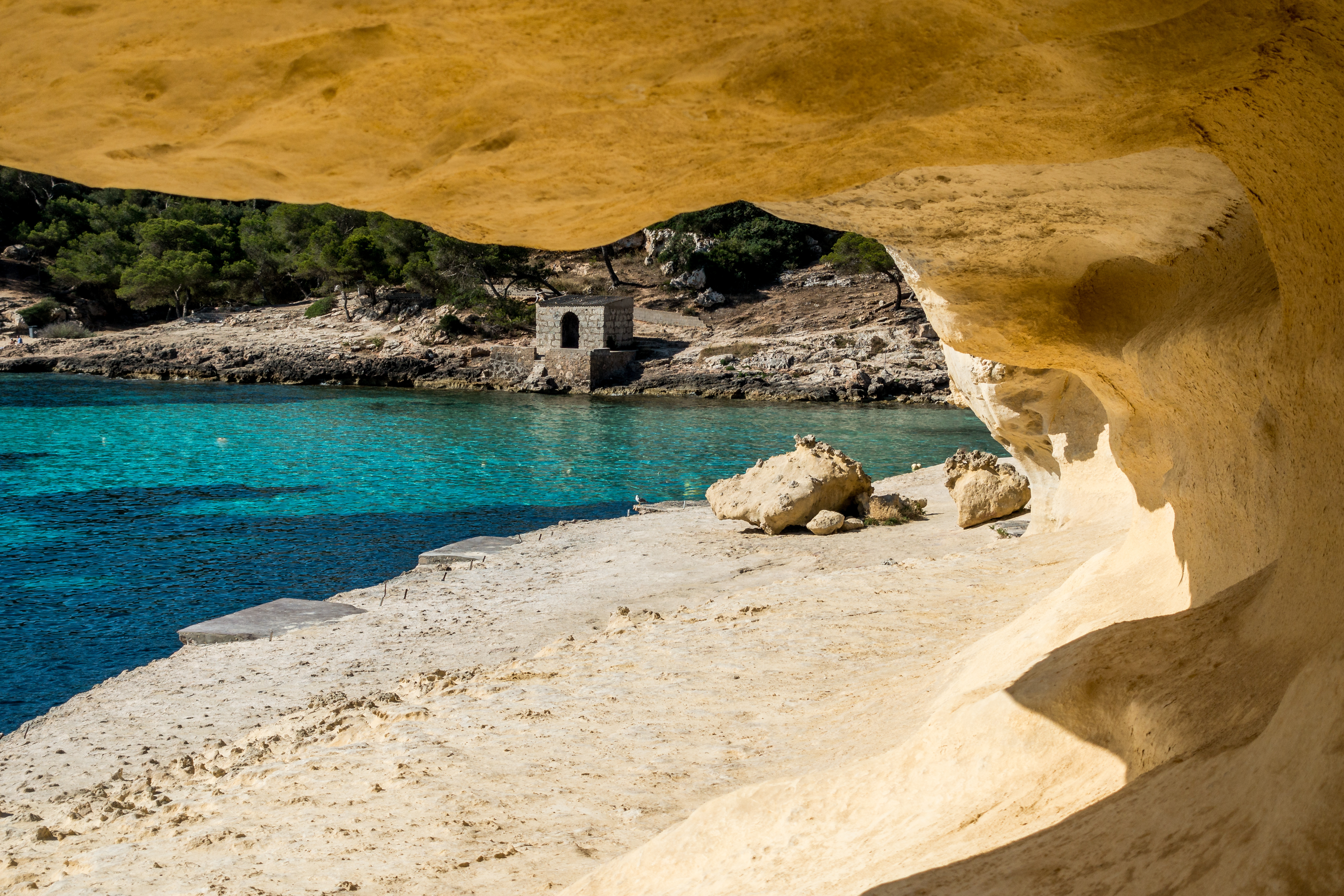 Blick durch einen Kalksteinfelsen auf die Felsküste von Portals Vells