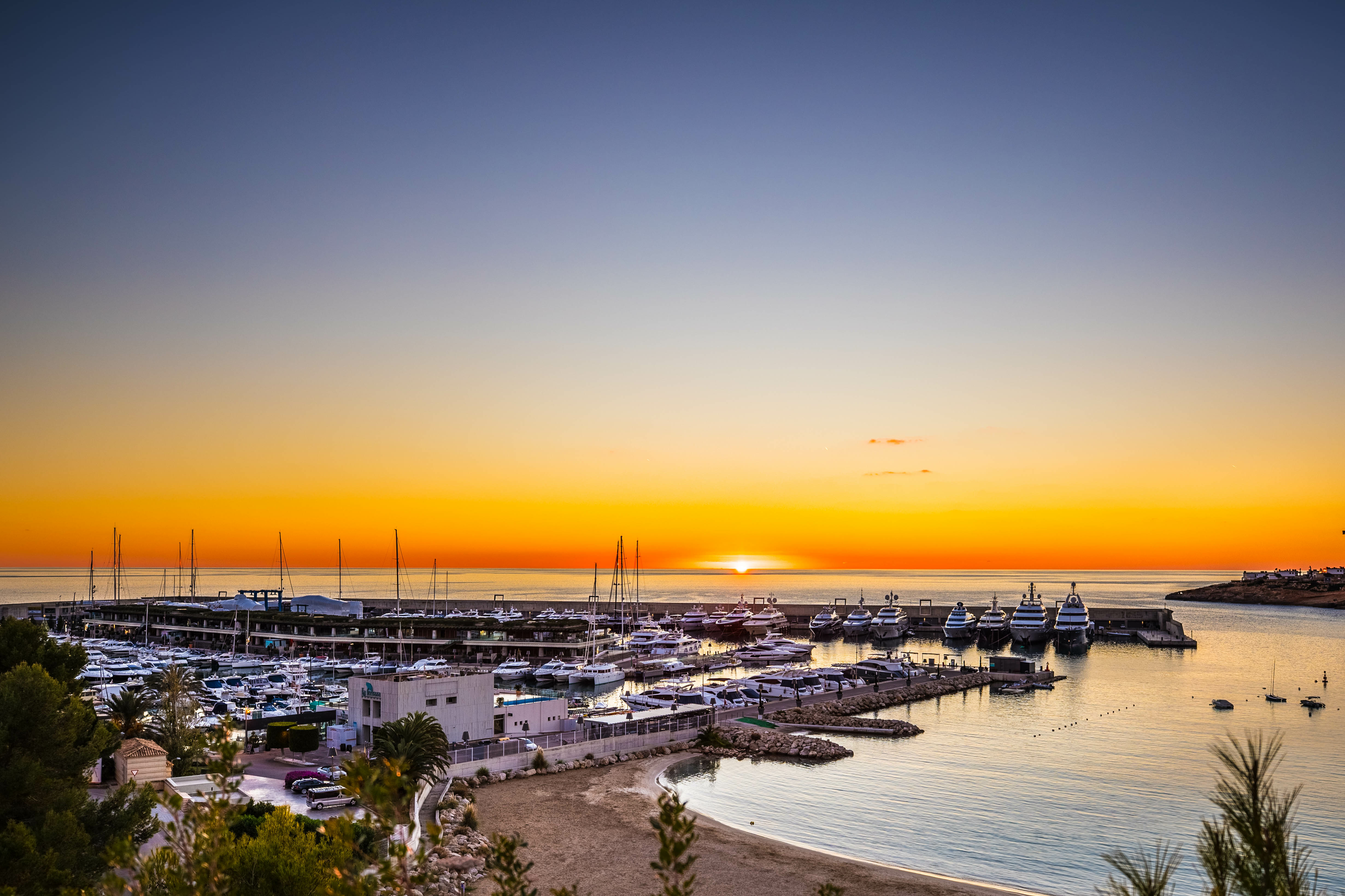 Puesta de sol sobre los yates de lujo en Port Adriano