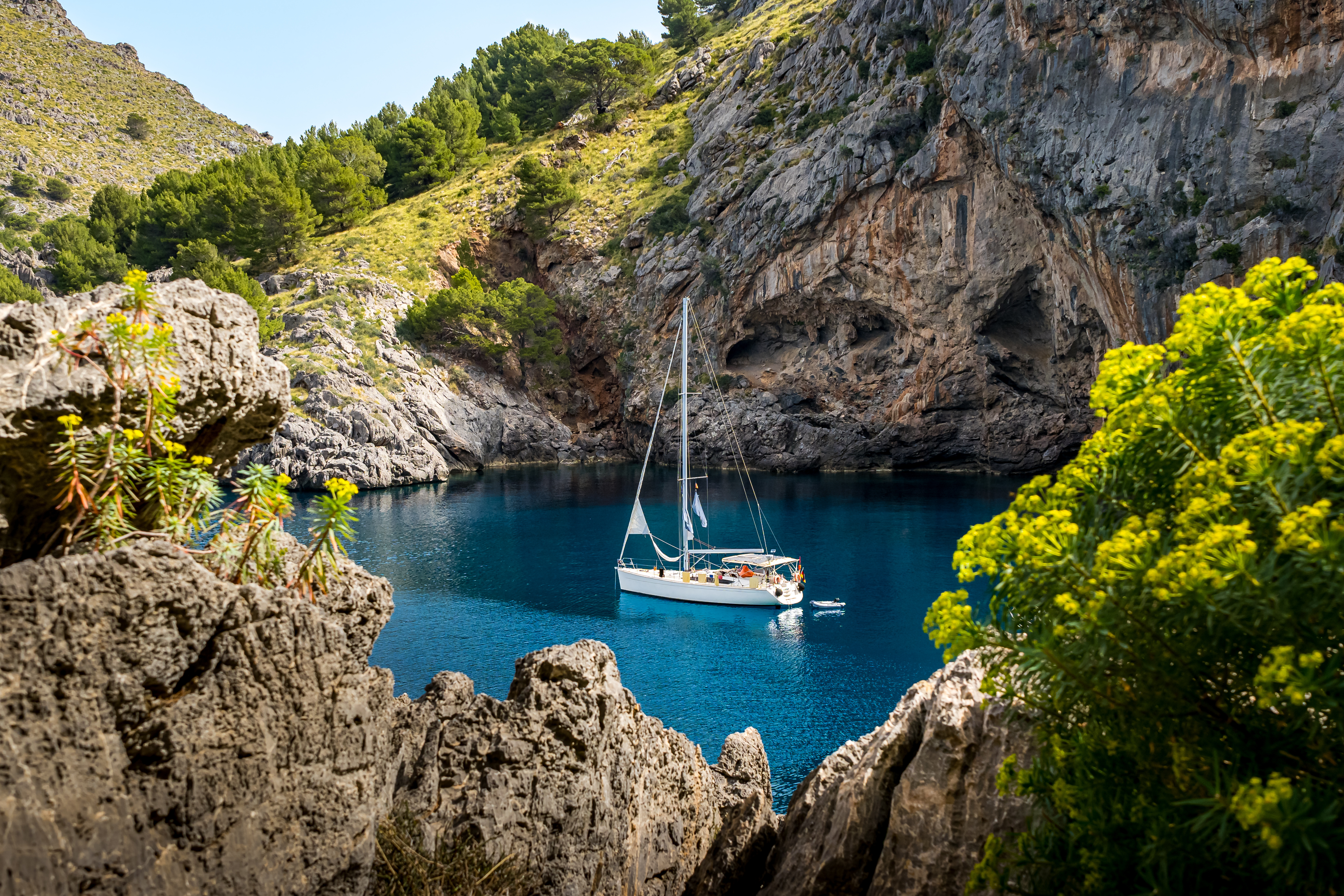 Osamocený jacht v skalnaté zátoce Sa Cala