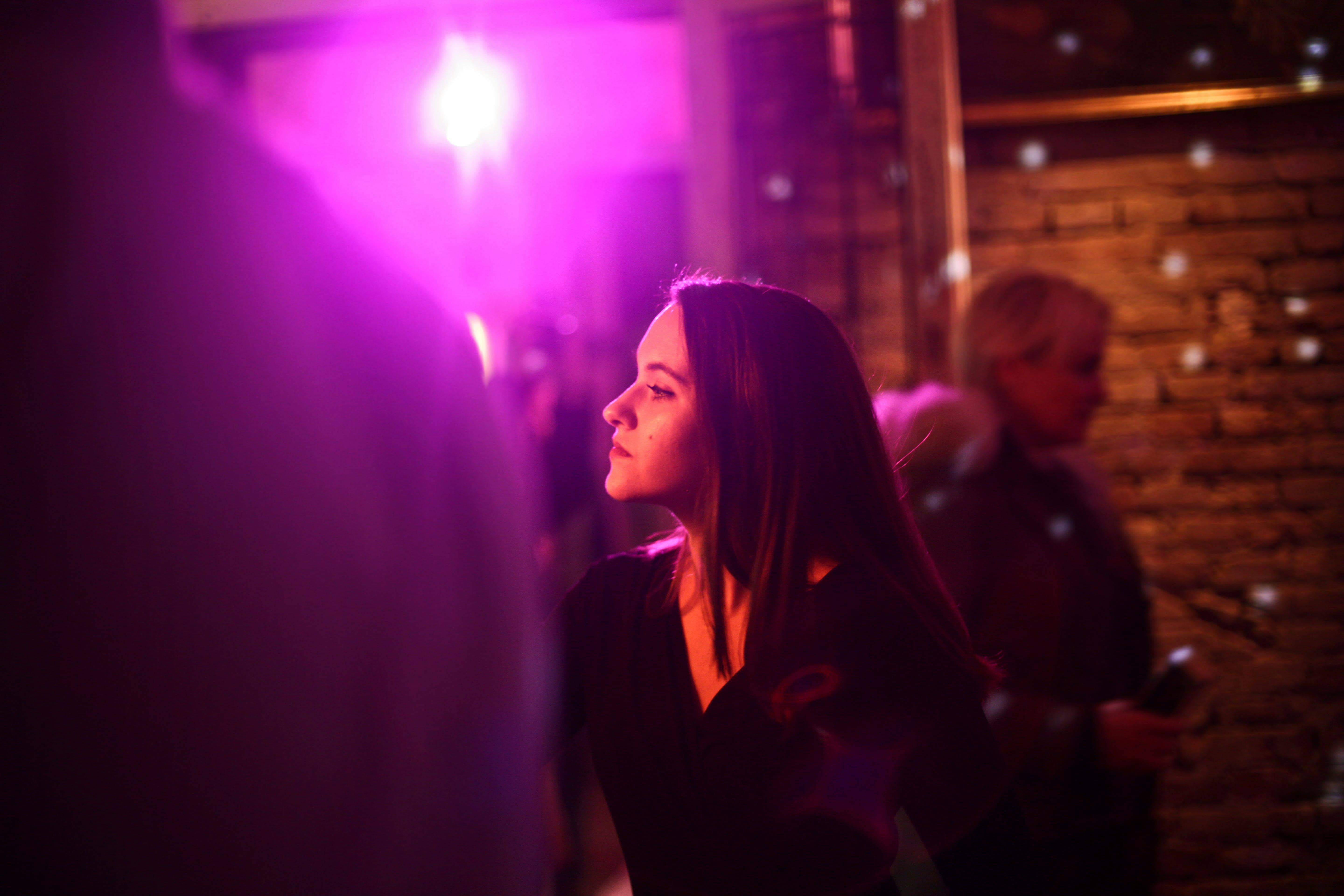 Young, attractive lady lit in purple in a club