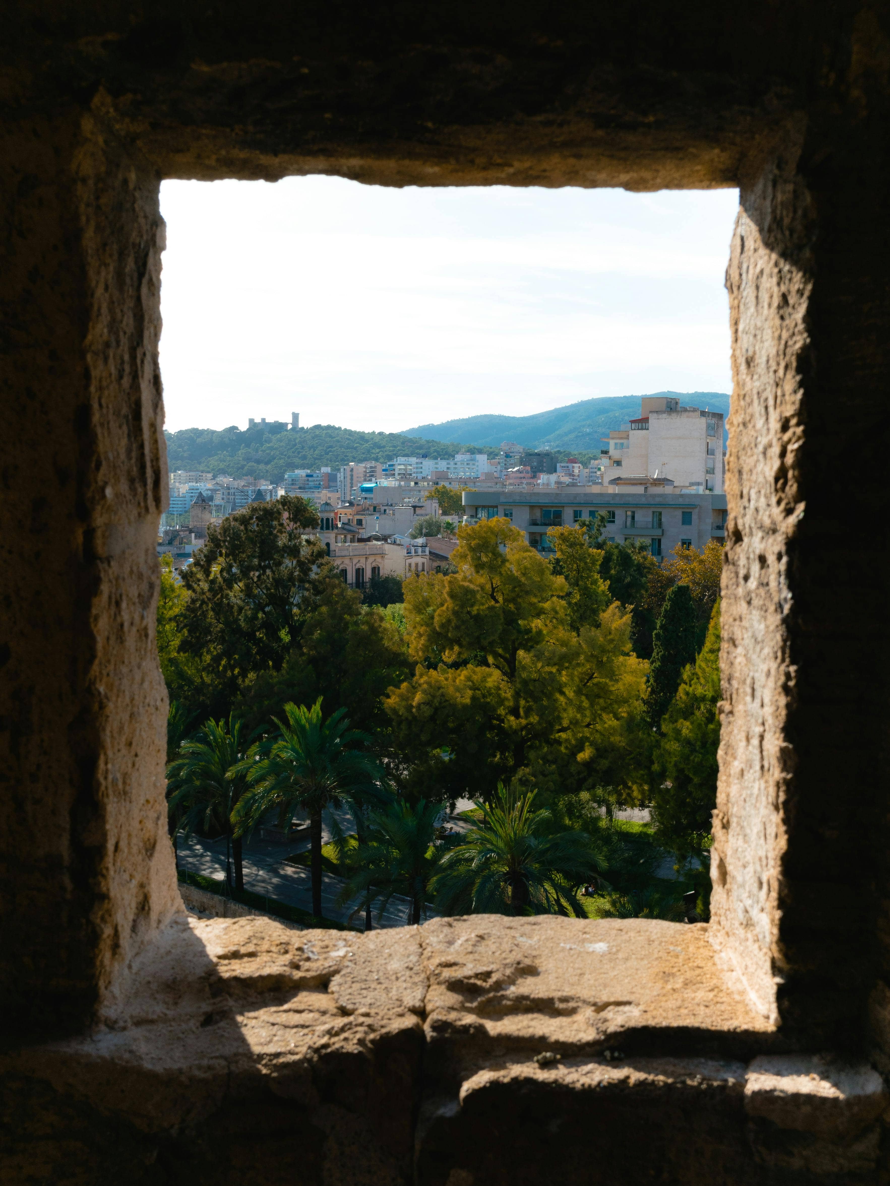 Uitzicht door een raam in een kasteelmuur op Palma