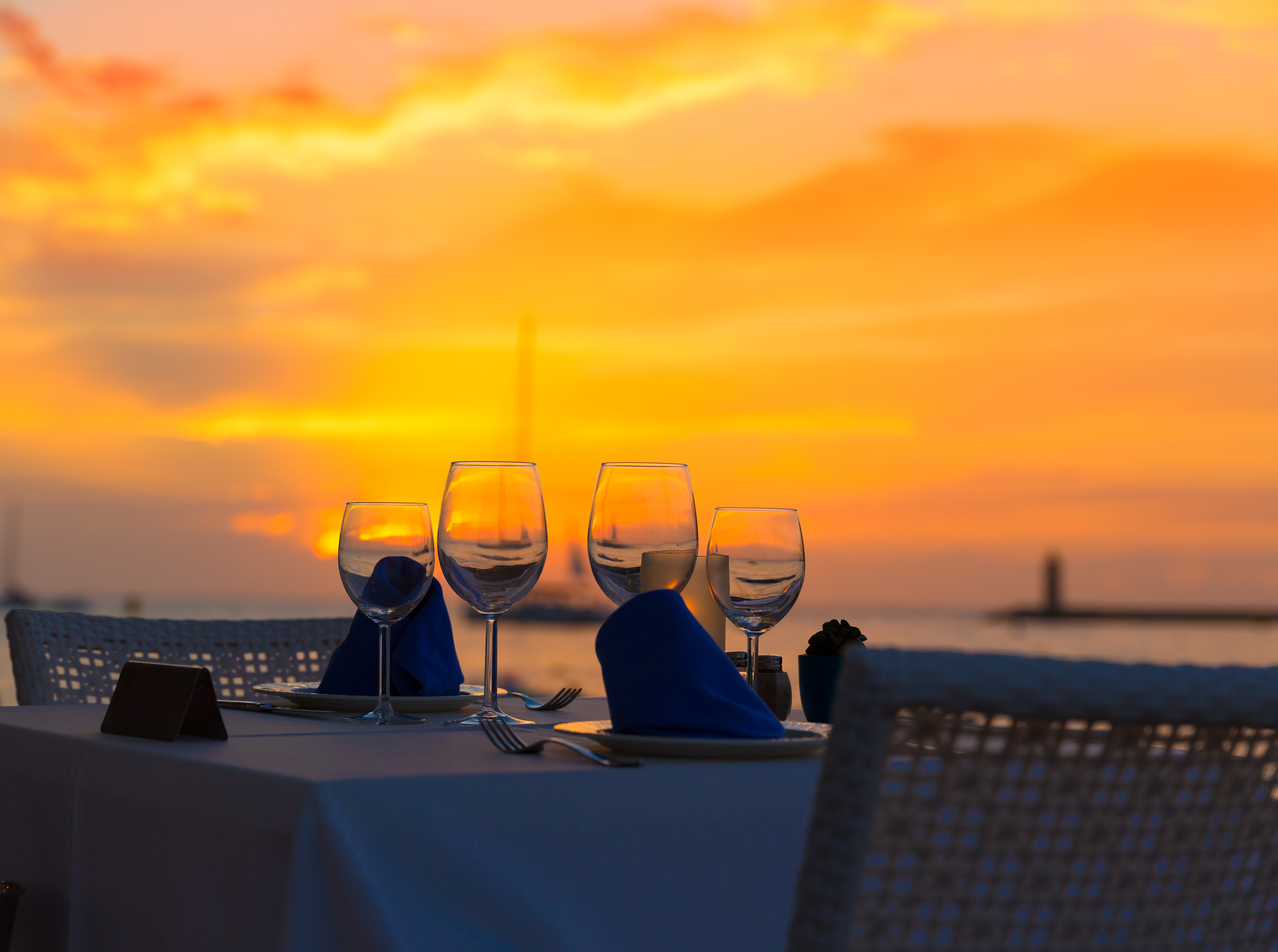 Gün batımından hemen önce arka planda akşam alacakaranlığı ile restoran masası